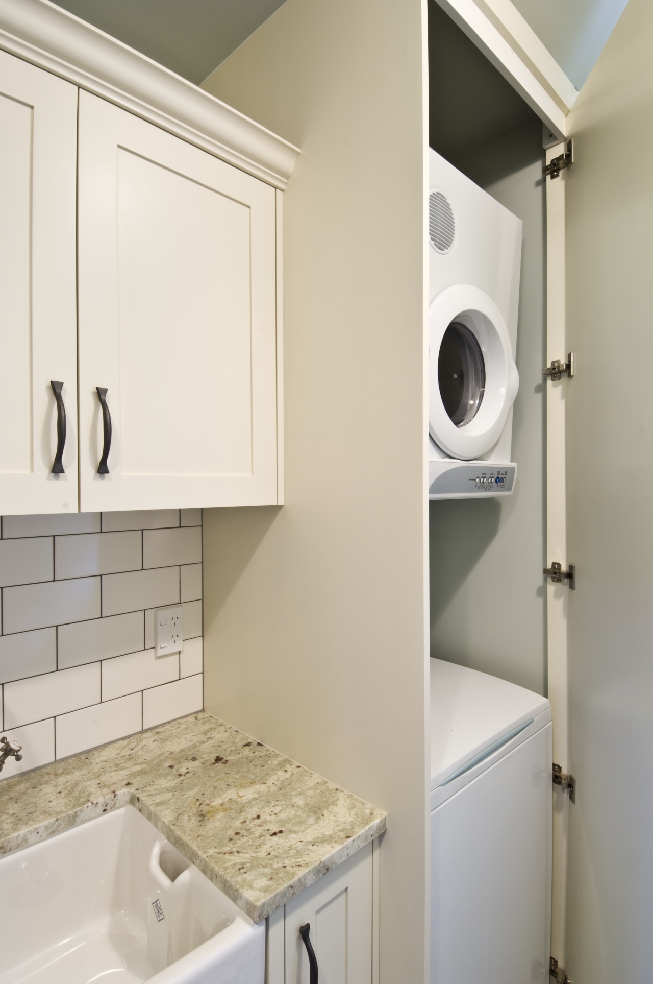 View of laundry, featuring a white butler's sink, bathroom, bathroom accessory, bathroom cabinet, clothes dryer, countertop, floor, home, home appliance, kitchen, laundry, laundry room, major appliance, room, sink, tap, gray