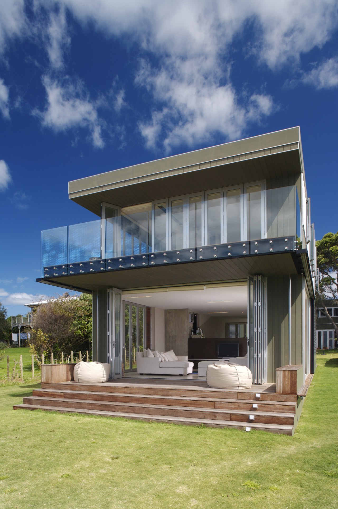 Exterior view of a holiday home with glass architecture, building, elevation, estate, facade, home, house, property, real estate, residential area, sky, villa, blue