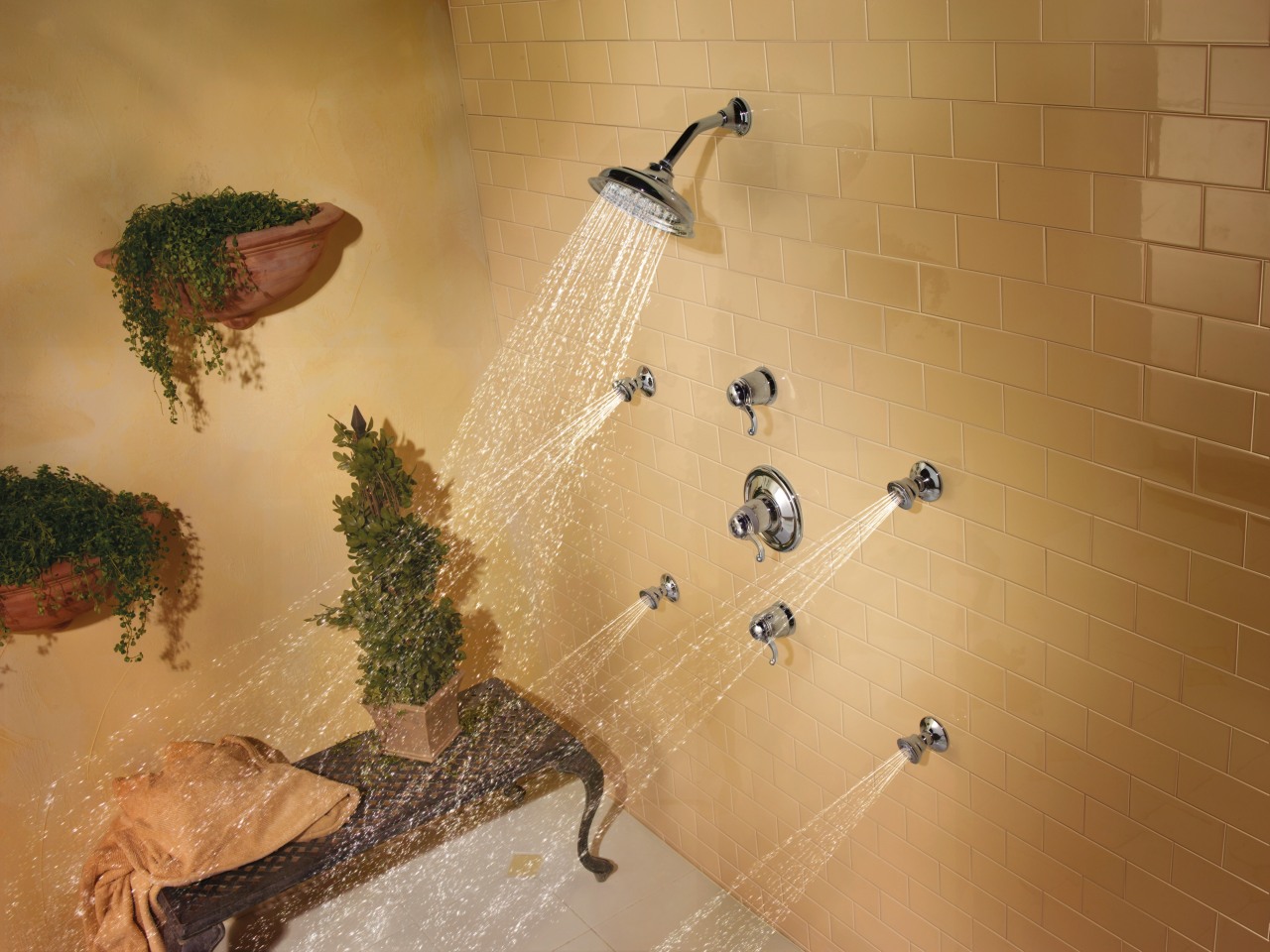 view of shower enclosure which features the showerheads fauna, tile, wall, orange, brown