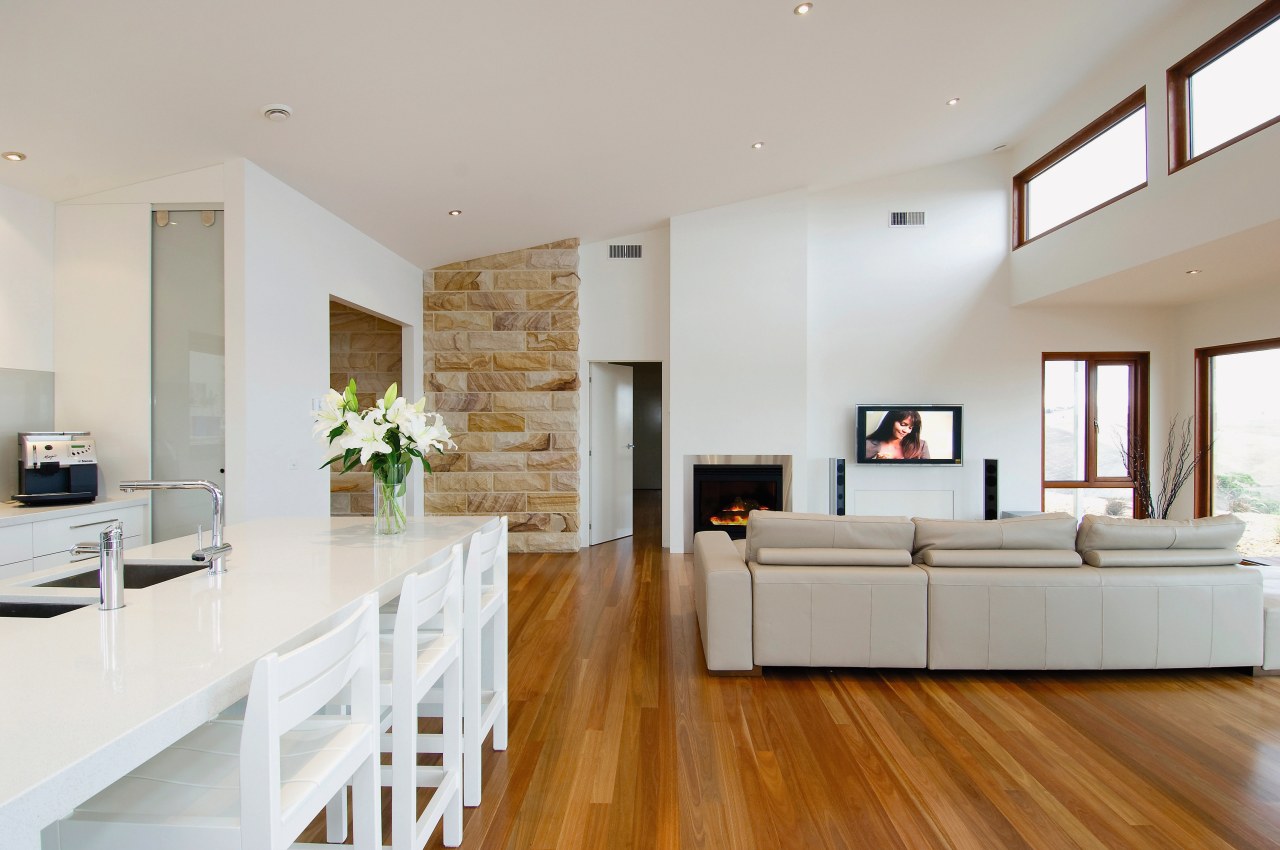 View of the lounge and kitchen areas of ceiling, floor, flooring, hardwood, home, house, interior design, interior designer, laminate flooring, living room, property, real estate, room, wood flooring, gray