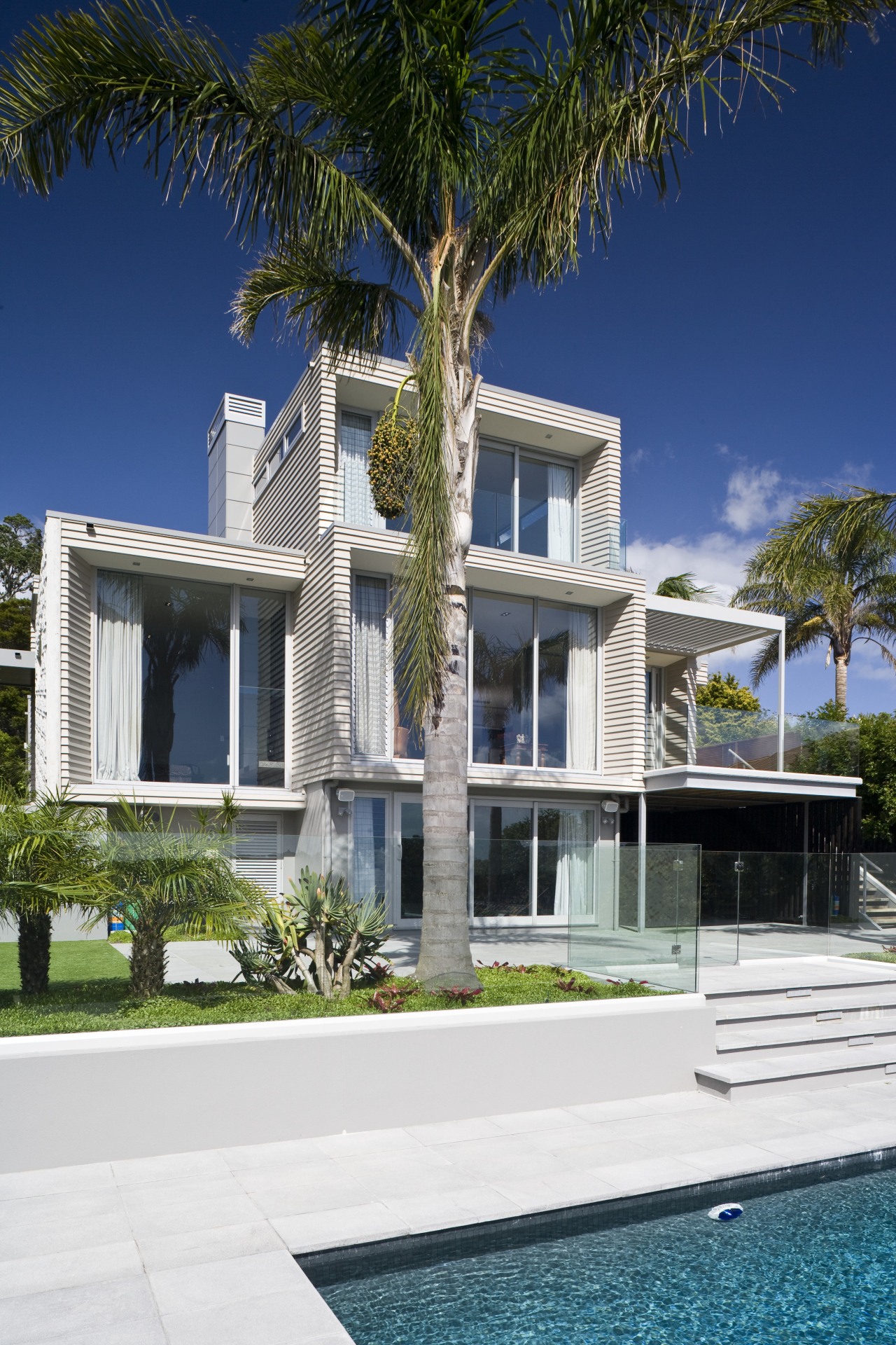 Exterior view of the rear of the renovated apartment, architecture, arecales, building, condominium, cottage, elevation, estate, facade, home, house, mansion, palm tree, property, real estate, residential area, resort, swimming pool, villa, window, white