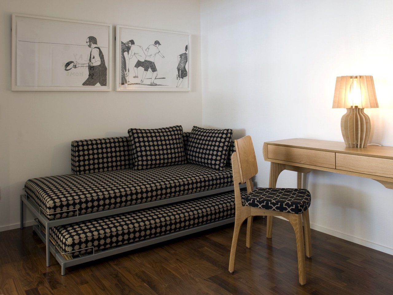 View of a second bedroom which features a chair, coffee table, couch, floor, flooring, furniture, hardwood, home, interior design, living room, loveseat, room, sofa bed, studio couch, table, wall, wood, gray, brown