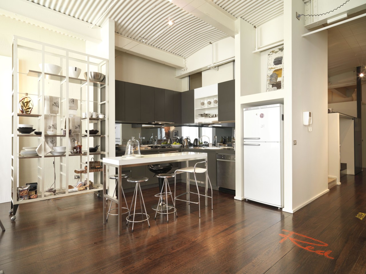 View of kitchen area with dark-stained timber flooring, floor, flooring, interior design, kitchen, loft, wood flooring, white, brown