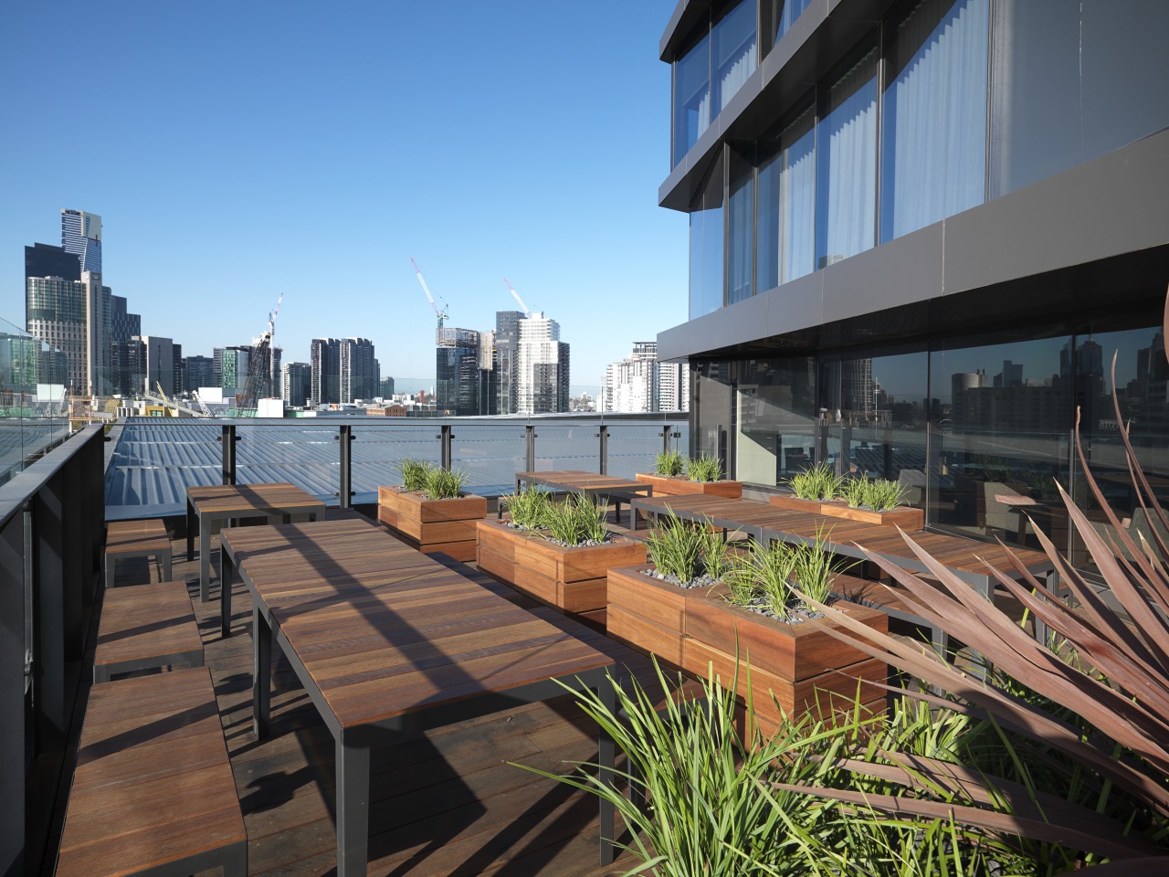 View of a deck at the Hilton Melbourne apartment, architecture, balcony, building, city, cityscape, condominium, daytime, downtown, metropolis, metropolitan area, mixed use, outdoor structure, real estate, residential area, roof, sky, skyline, skyscraper, urban area, urban design, walkway, teal, black