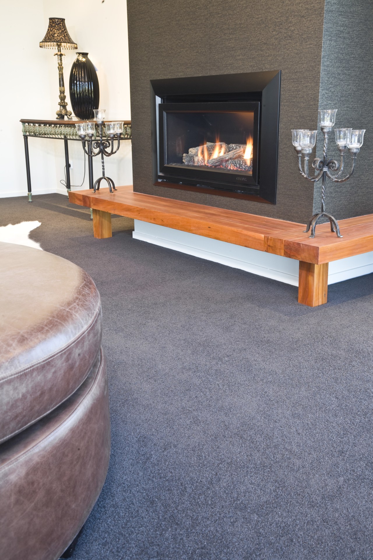 View of the lounge which was designed by coffee table, fireplace, floor, flooring, furniture, hardwood, hearth, laminate flooring, living room, table, wood, wood burning stove, wood flooring, gray