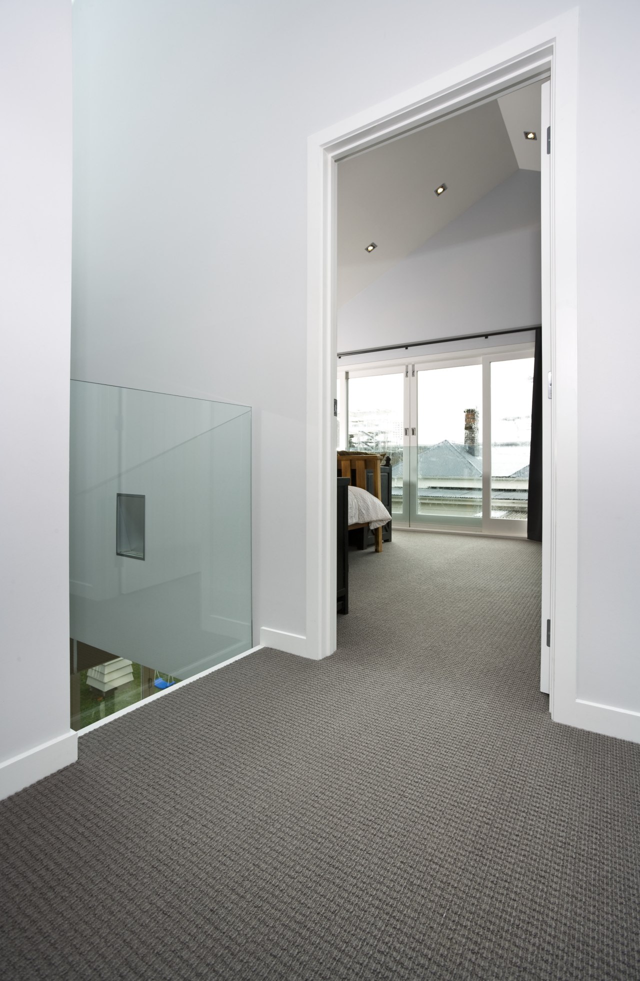 View of a bedroom area which features pure architecture, daylighting, door, floor, flooring, glass, house, interior design, laminate flooring, real estate, window, wood flooring, white, gray