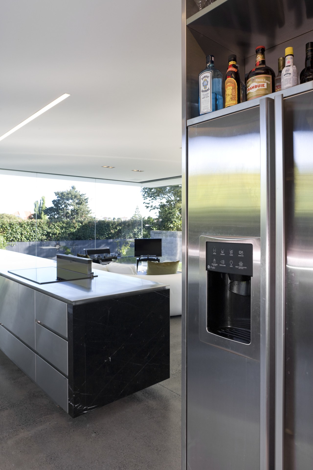 View of open-plan kitchen featuring polished concrete flooring, countertop, home appliance, interior design, kitchen, major appliance, white, black, gray