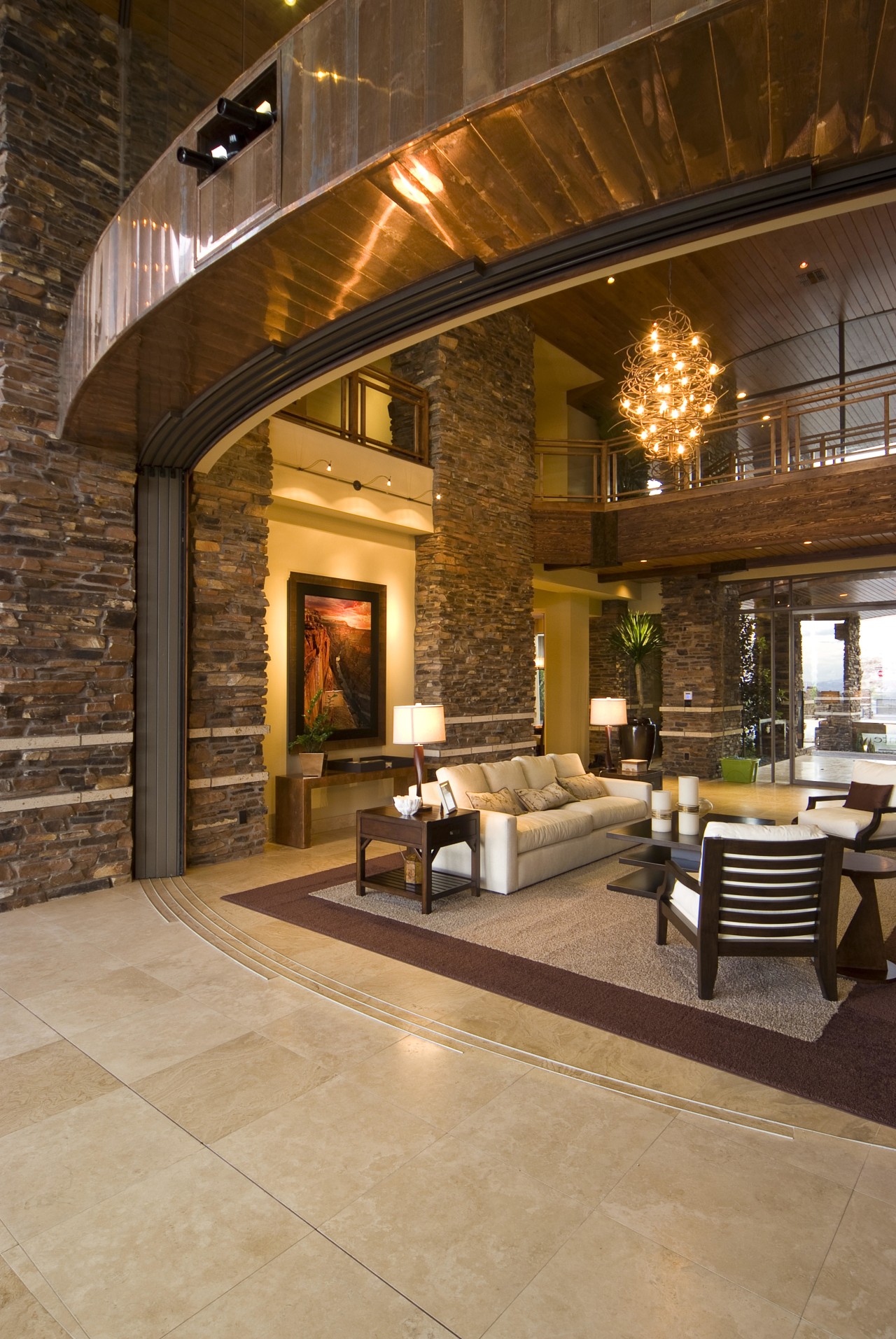 View of the living area which features tiled brick, ceiling, estate, fireplace, floor, flooring, hardwood, hearth, home, interior design, lighting, living room, lobby, patio, real estate, wood flooring, brown, orange