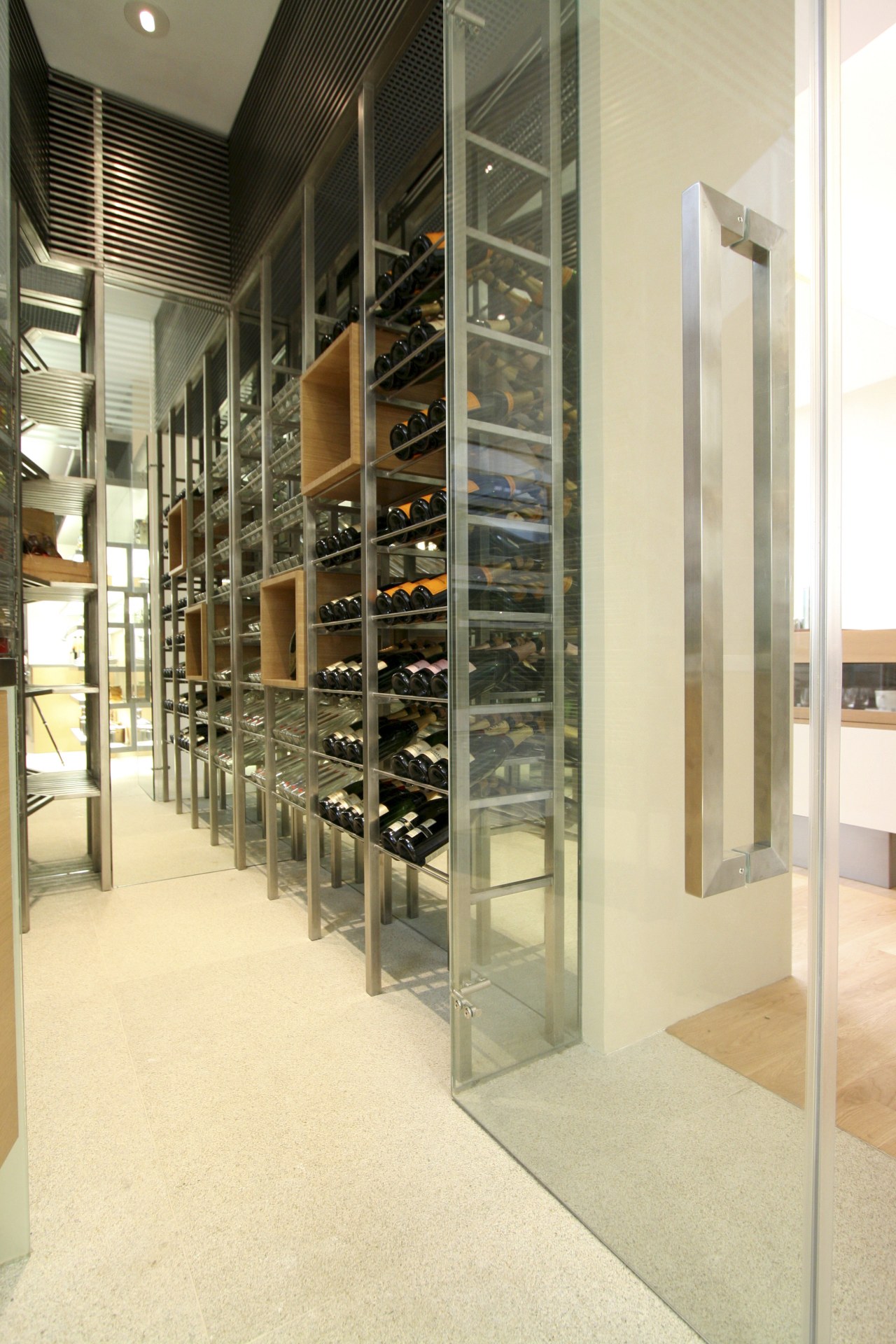 View of wet kitchen featuring a walk-in chiller floor, flooring, glass, interior design, shelving, orange, brown