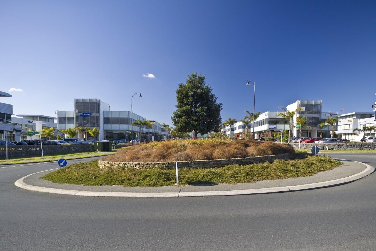 external view of inteplex@albany developed by northbridge properties. asphalt, car, city, daytime, infrastructure, neighbourhood, real estate, residential area, road, sky, traffic circle, tree, gray, teal