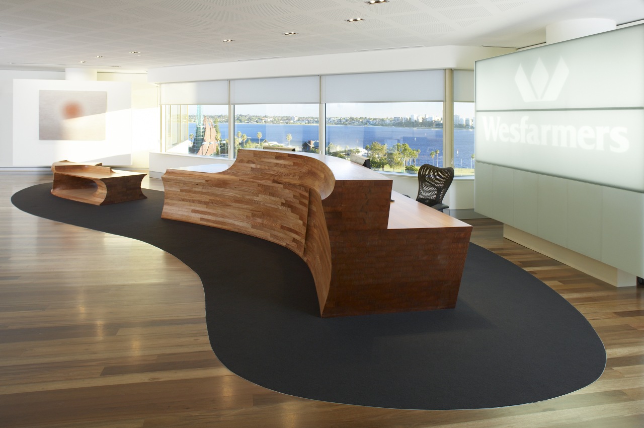 View of the reception area which features a desk, floor, flooring, furniture, hardwood, interior design, office, product design, table, wood, brown