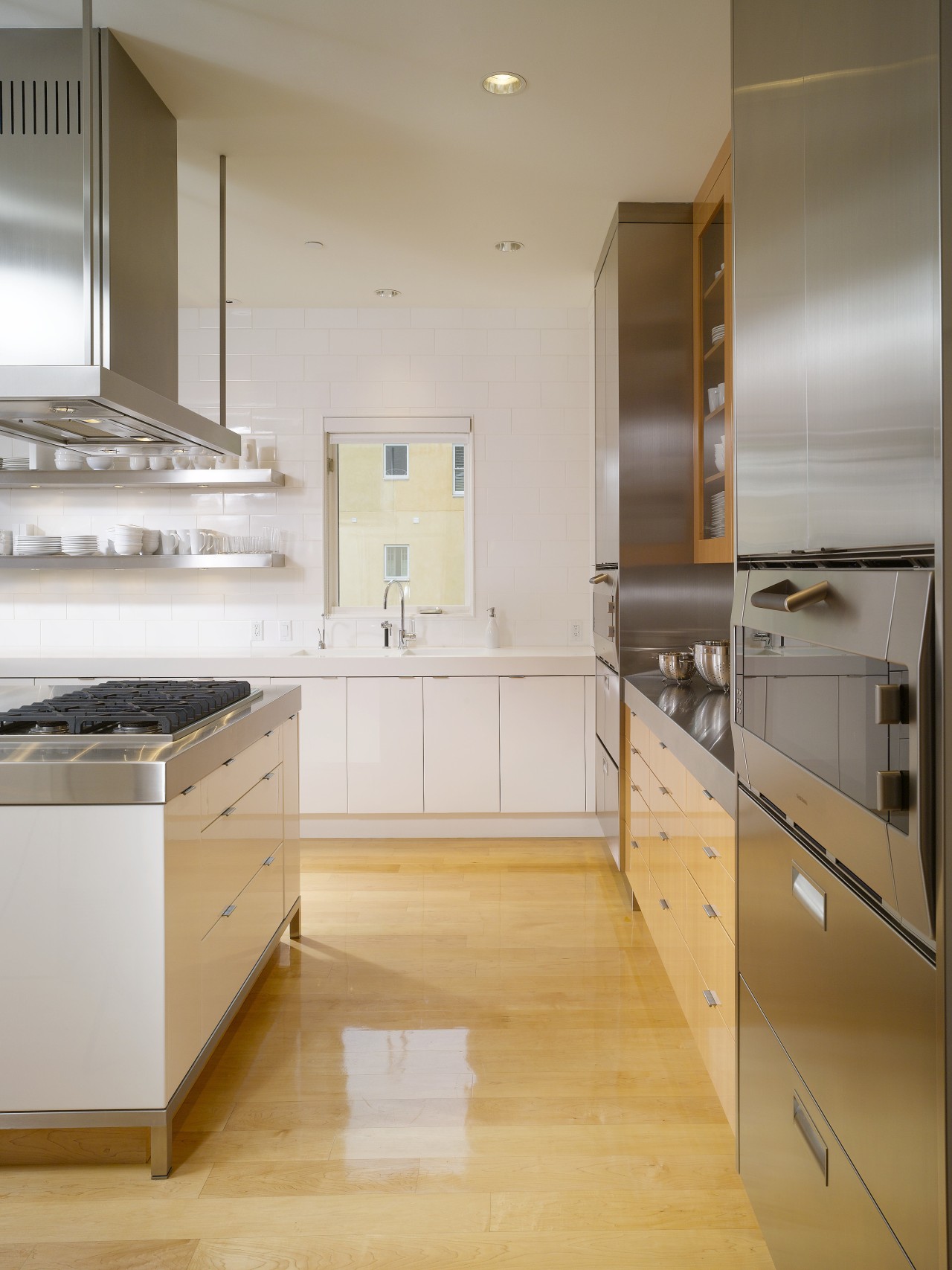 View of a condominium kitchen which features a cabinetry, countertop, cuisine classique, floor, flooring, hardwood, interior design, kitchen, laminate flooring, room, wood flooring, gray, orange