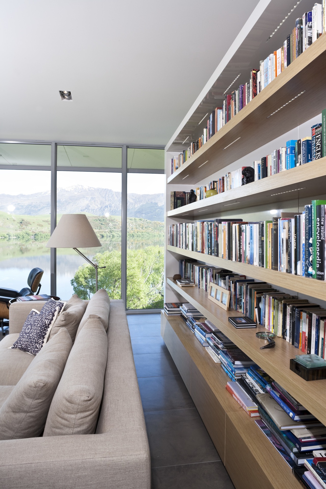 View of kitchen and living area featuring light interior design, living room, shelving, gray