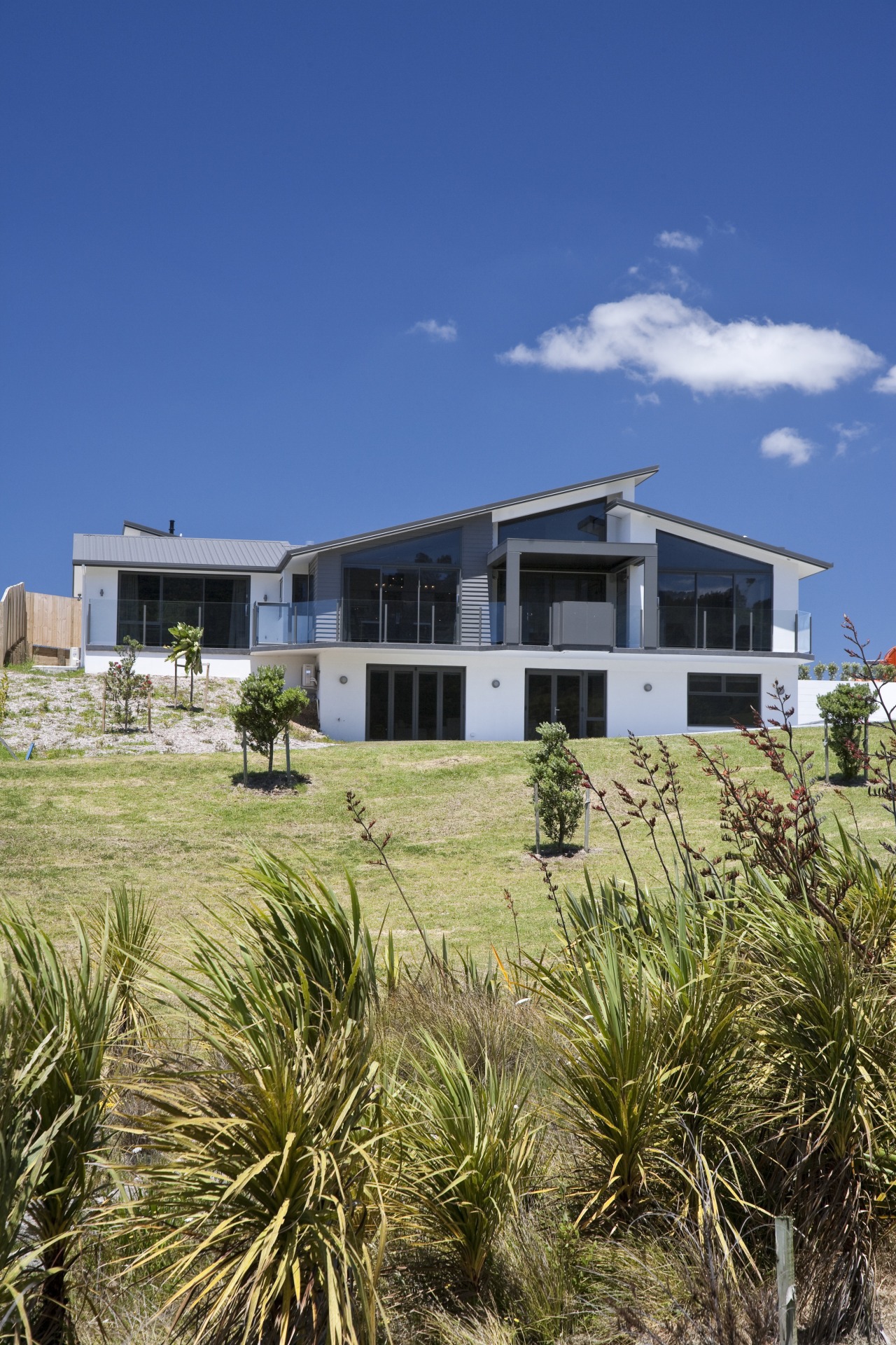 This home, by David Reid Homes Hauraki, features architecture, cottage, estate, grass, home, house, land lot, property, real estate, residential area, sky, blue