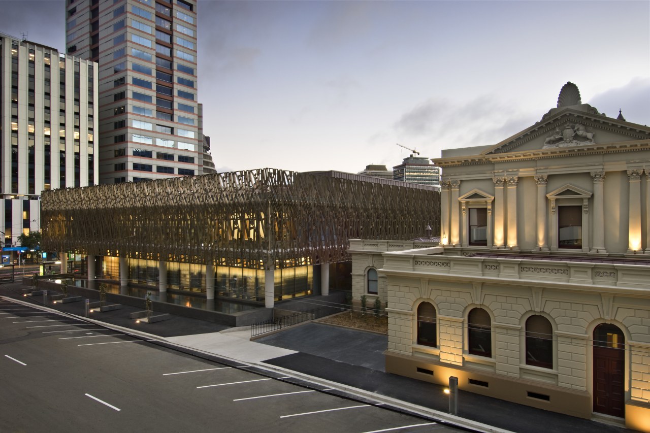 Exterior view of the Supreme Court which features architecture, building, car, city, cityscape, downtown, evening, facade, infrastructure, landmark, metropolis, metropolitan area, neighbourhood, plaza, road, sky, skyscraper, street, town square, transport, urban area, gray, brown