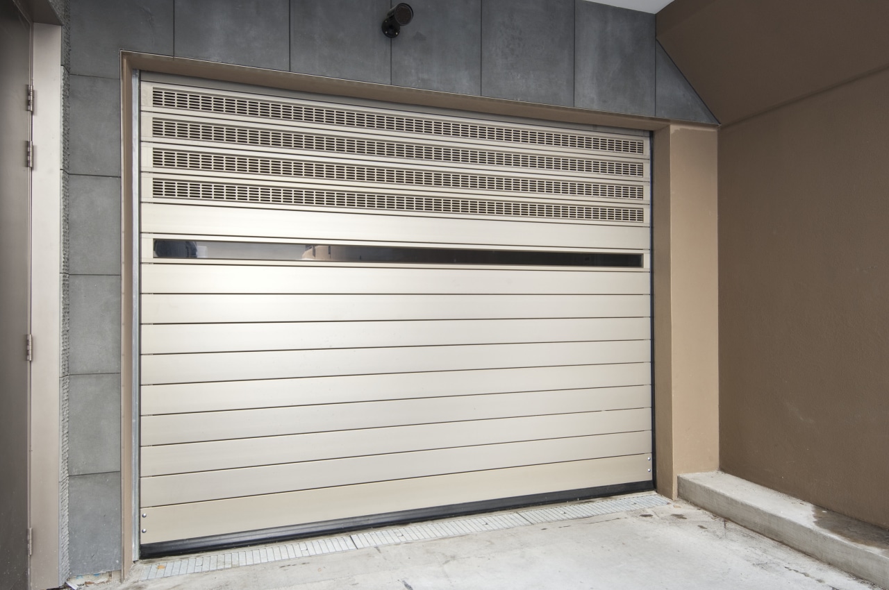 View of an underground carpark which features a door, garage, garage door, window, white