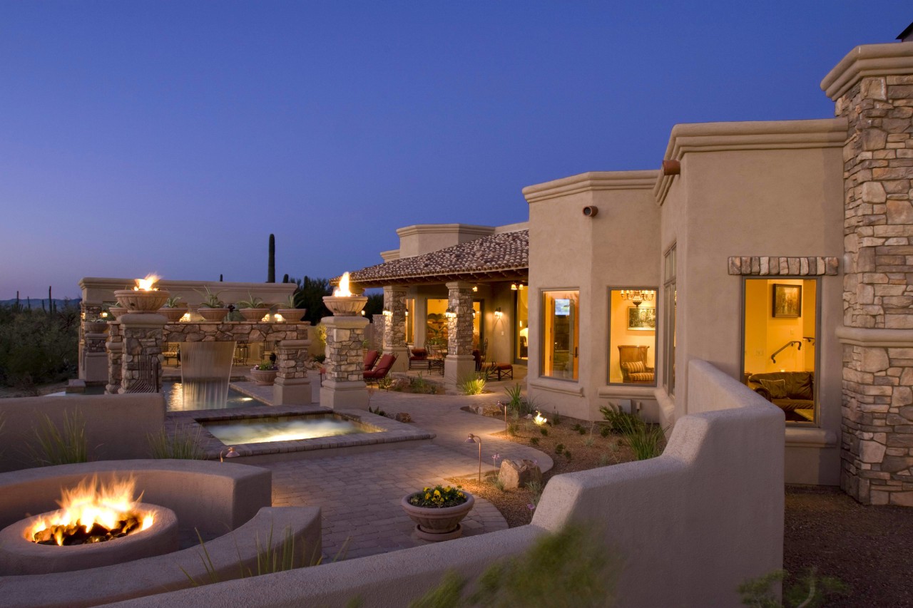 Exterior view of this home featuring unique landscape estate, evening, hacienda, home, hotel, landscape lighting, lighting, property, real estate, resort, sky, villa, blue