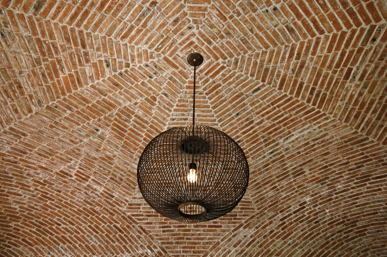 View of hacienda-style house with plastered walls, vaulted wood, brown, orange