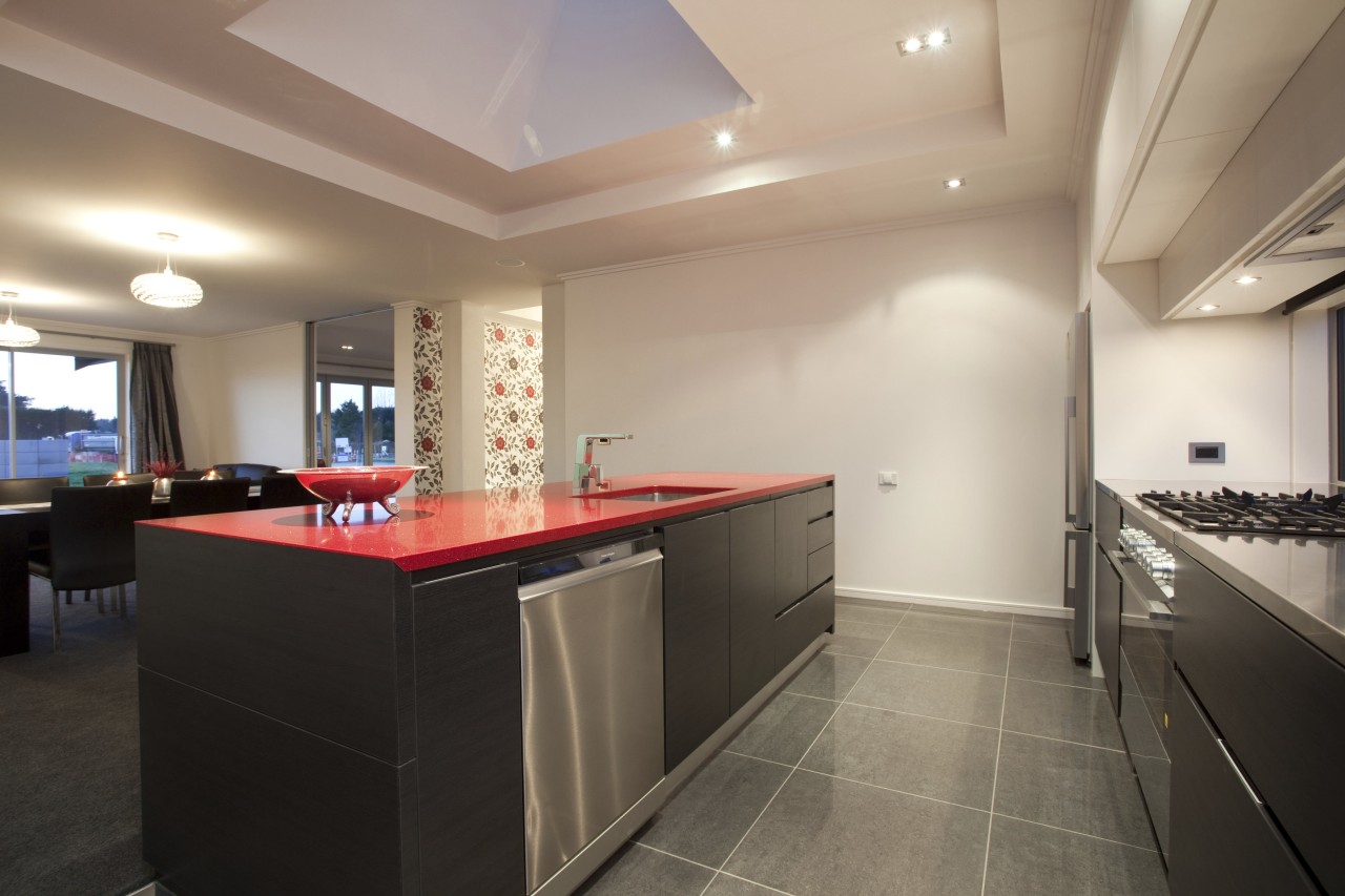 View of kitchen area which features kitchen island architecture, cabinetry, ceiling, countertop, floor, flooring, interior design, kitchen, real estate, room, gray