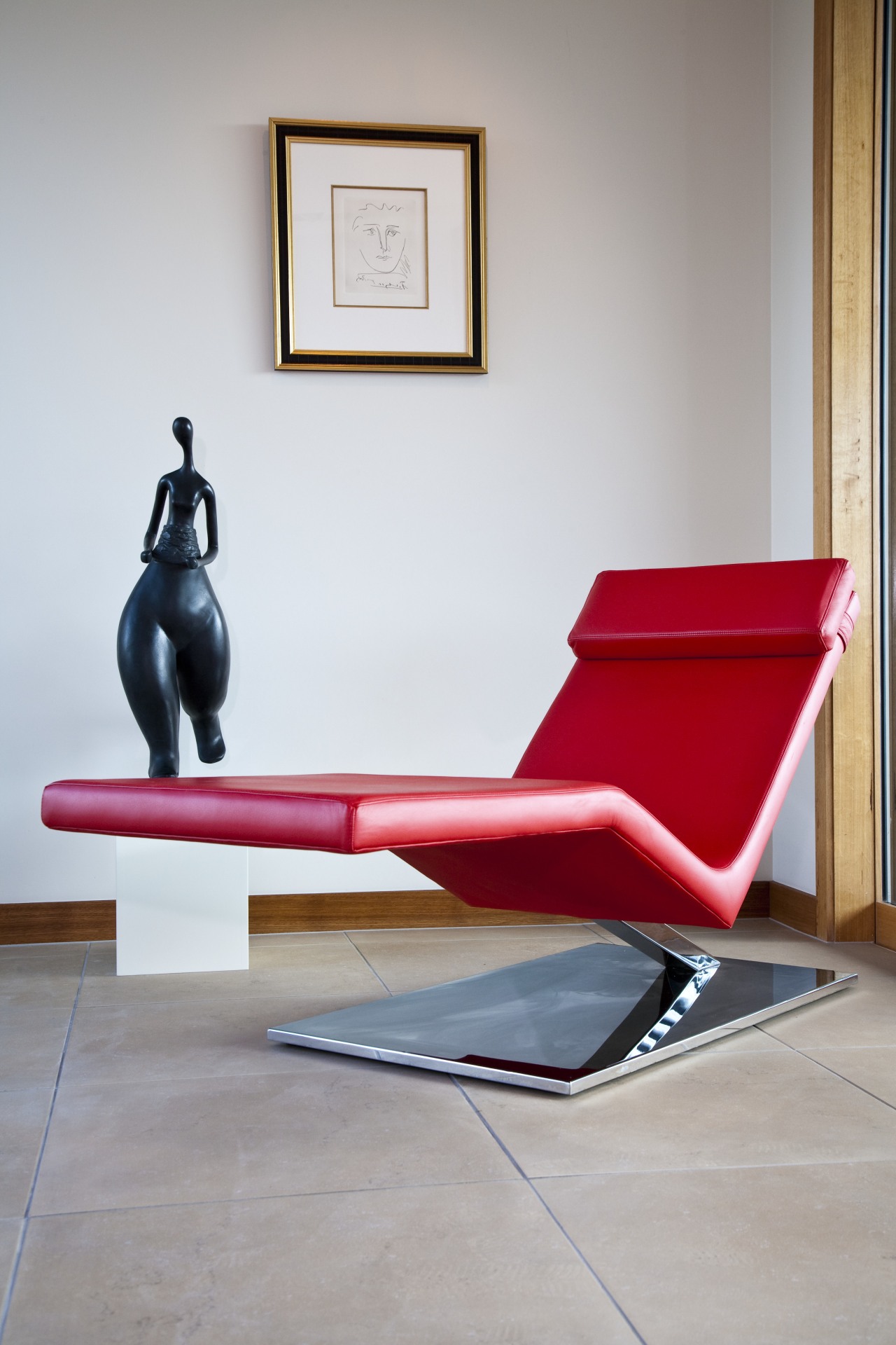 View of living area which features leather lounger chair, chaise longue, couch, floor, flooring, furniture, product design, sitting, table, gray, white