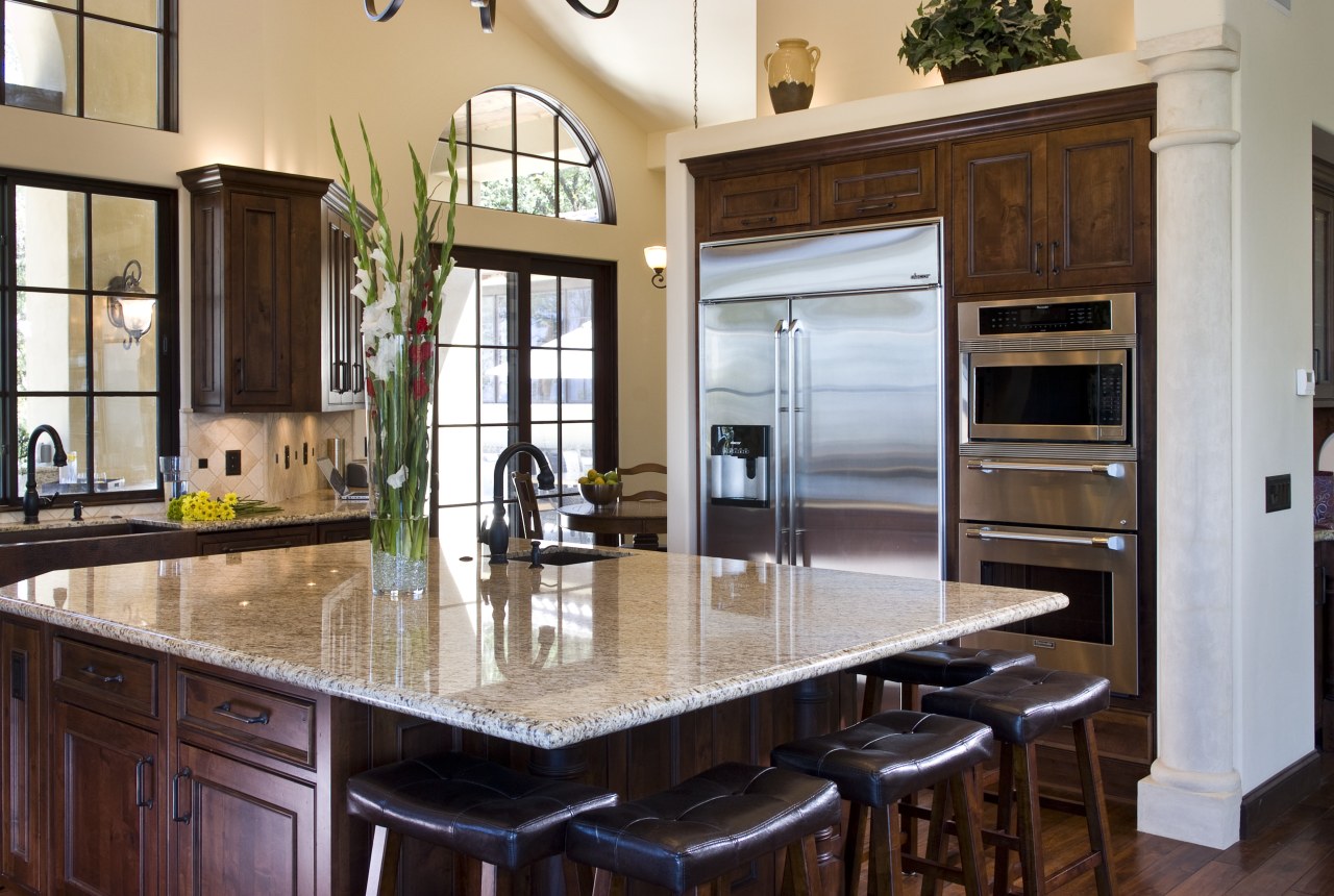 View of a Tuscan-styled kitchen which features dark-stained cabinetry, countertop, cuisine classique, interior design, kitchen, real estate, red