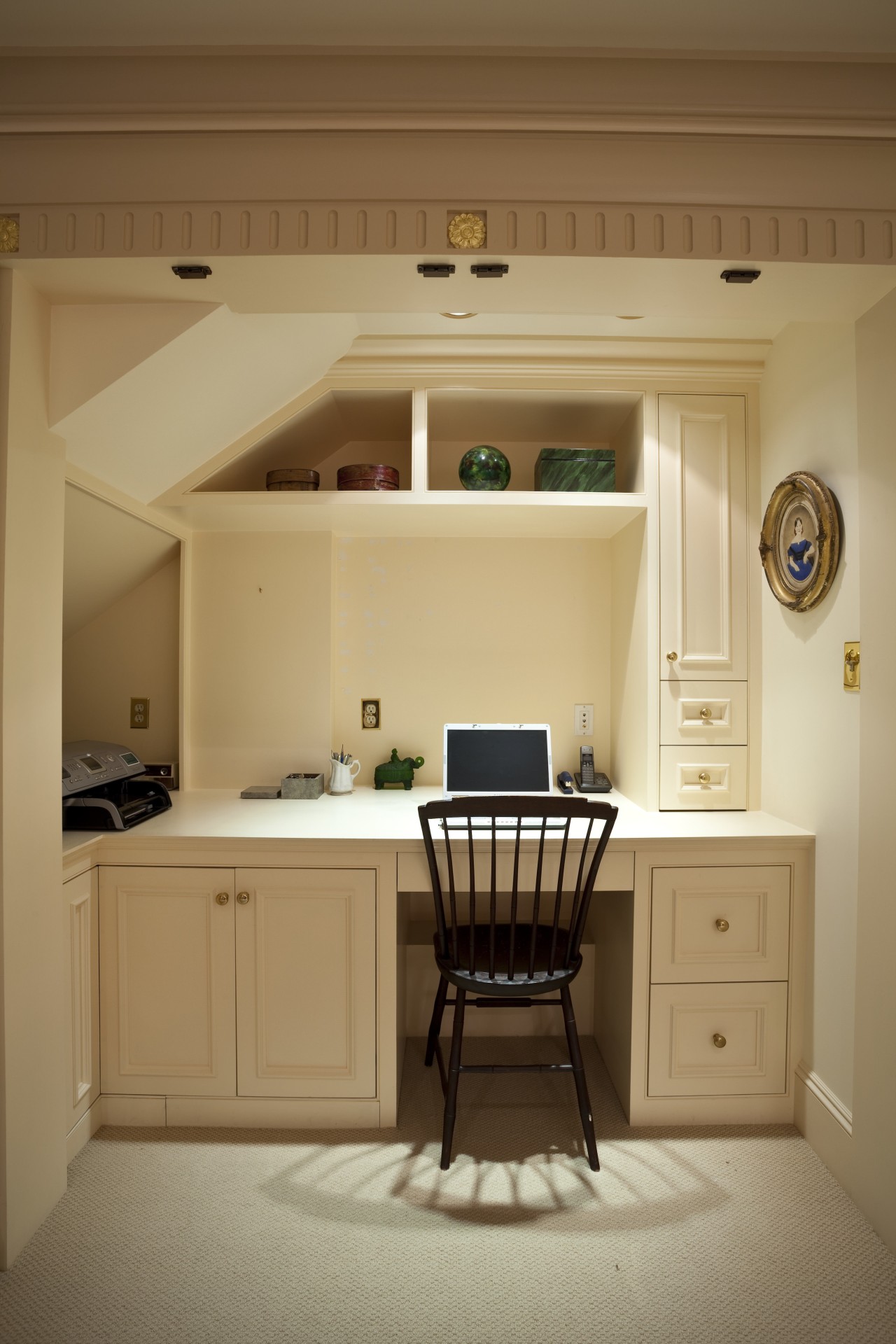 View of desk area under a staircase. cabinetry, ceiling, floor, furniture, home, interior design, kitchen, living room, room, table, wall, window, brown, orange