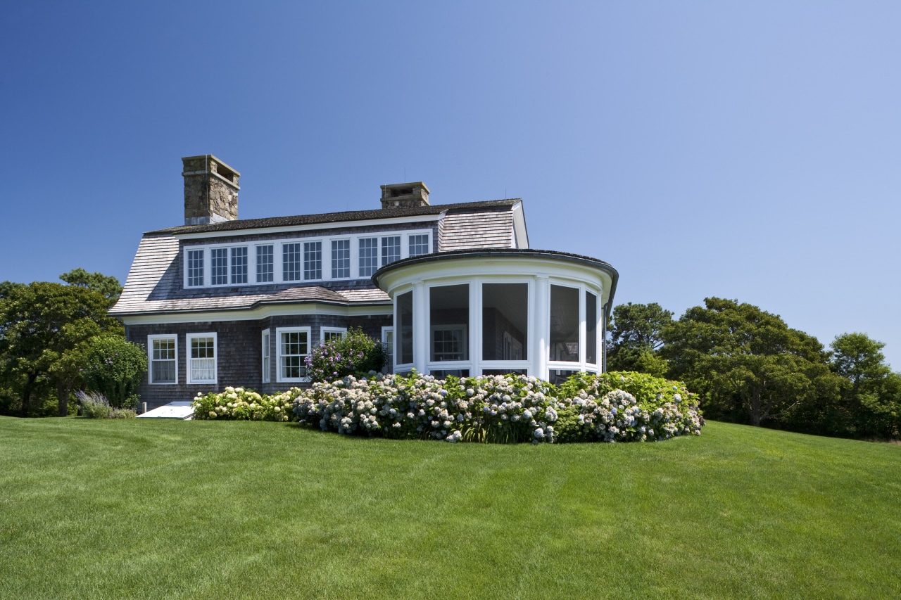 Exterior view of a New-England styled vacation home. cottage, estate, facade, farmhouse, grass, home, house, landscape, landscaping, lawn, mansion, plant, plantation, property, real estate, residential area, siding, sky, villa, window, teal