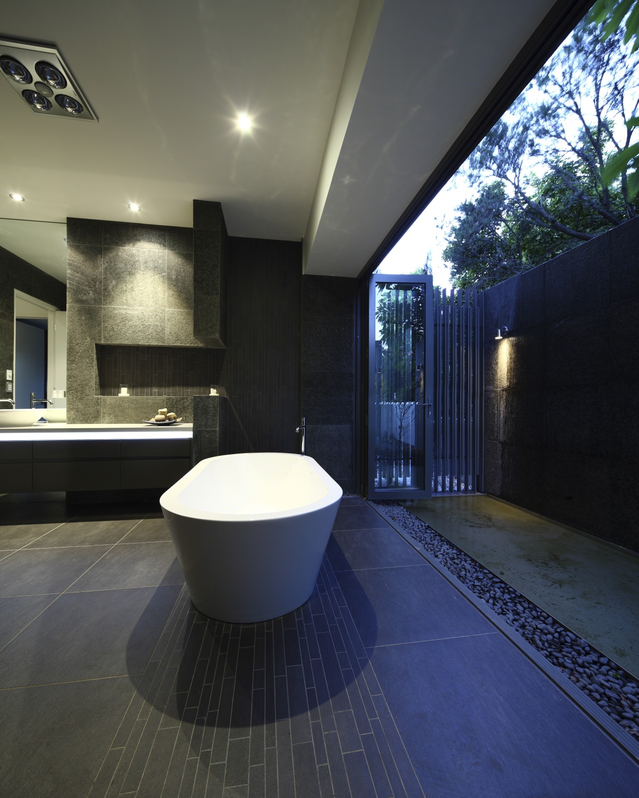 View of dark-toned bathroom with white tub. architecture, bathroom, ceiling, daylighting, estate, floor, flooring, home, house, interior design, lighting, property, real estate, tile, black, blue