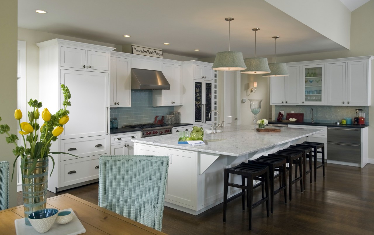 View of kitchen with wooden flooring, white cabinetry, cabinetry, countertop, cuisine classique, interior design, kitchen, living room, real estate, room, gray