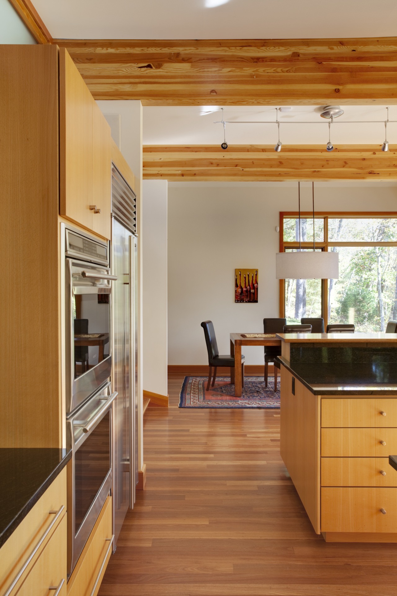 View of sunken open-plan kitchen with wooden cabinetry, architecture, cabinetry, ceiling, countertop, daylighting, floor, flooring, hardwood, house, interior design, kitchen, laminate flooring, real estate, room, wood, wood flooring, brown, orange