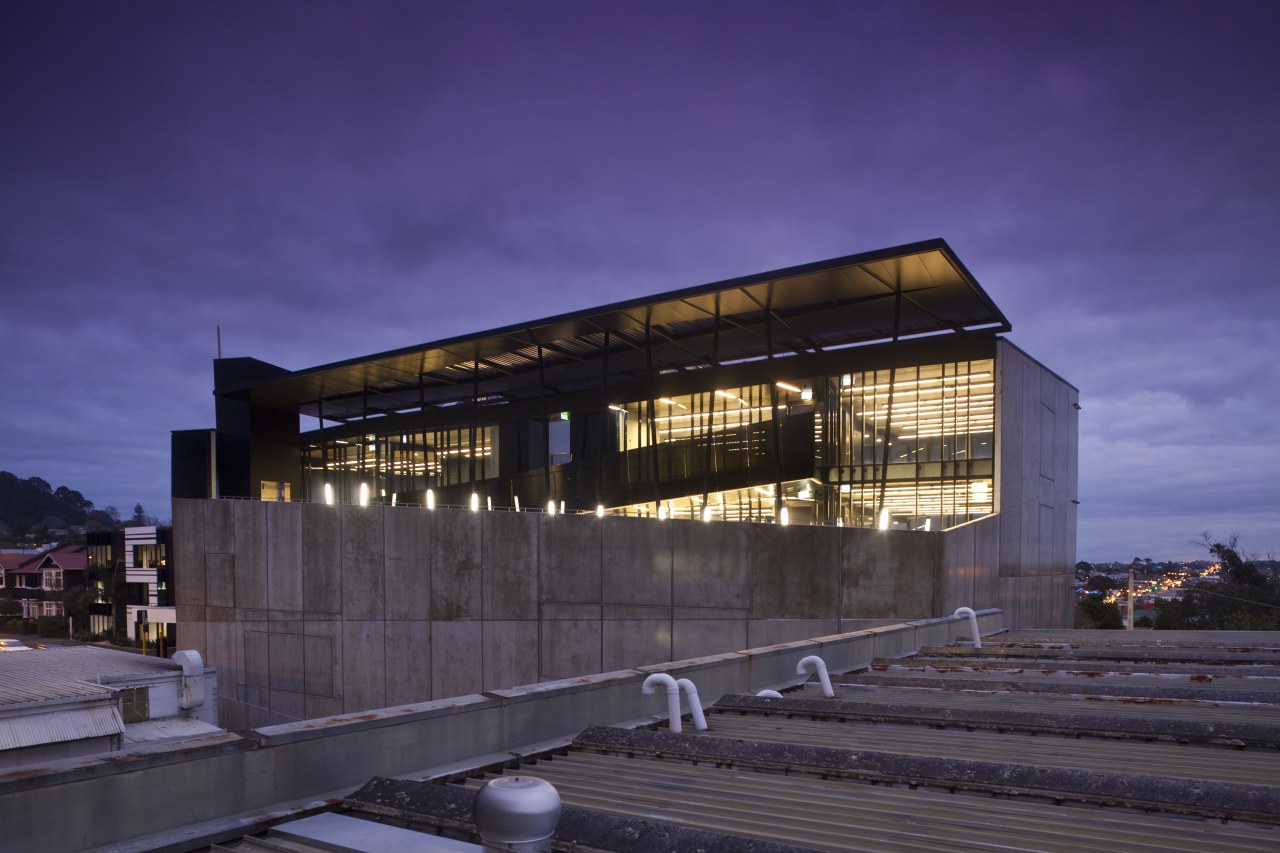 View of the Anvil Building, with angled custom architecture, building, corporate headquarters, evening, facade, headquarters, house, night, reflection, sky, structure, purple, black