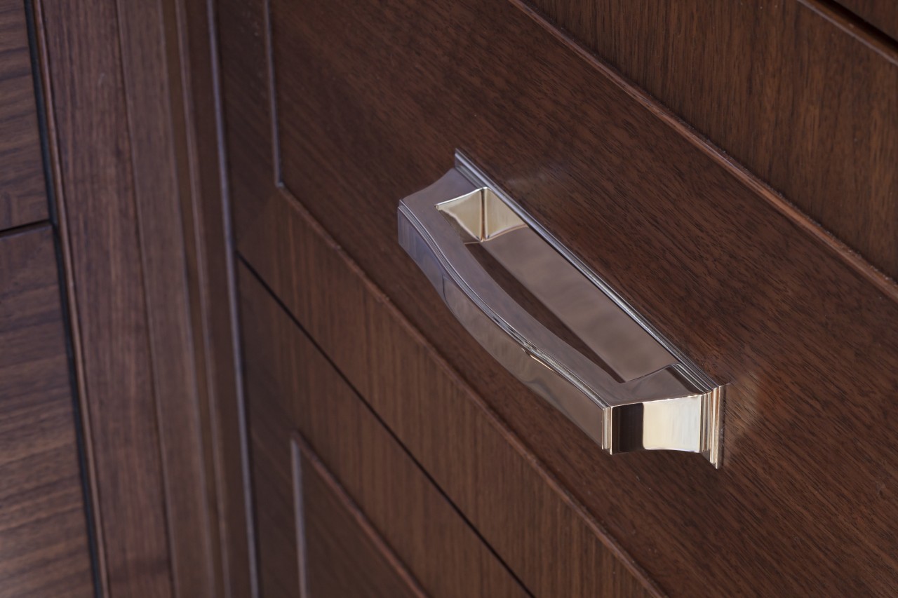 Stainless steel appliances.  Dark walnut surfaces. Custom angle, drawer, floor, hardwood, lighting, plywood, product design, wood, wood stain, red