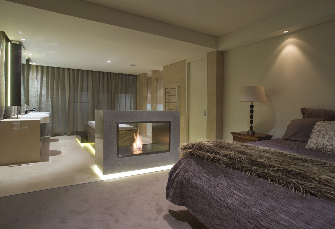 Bedroom with purple bedspread and fireplace. bed frame, bedroom, ceiling, floor, hearth, interior design, property, real estate, room, suite, wall, brown