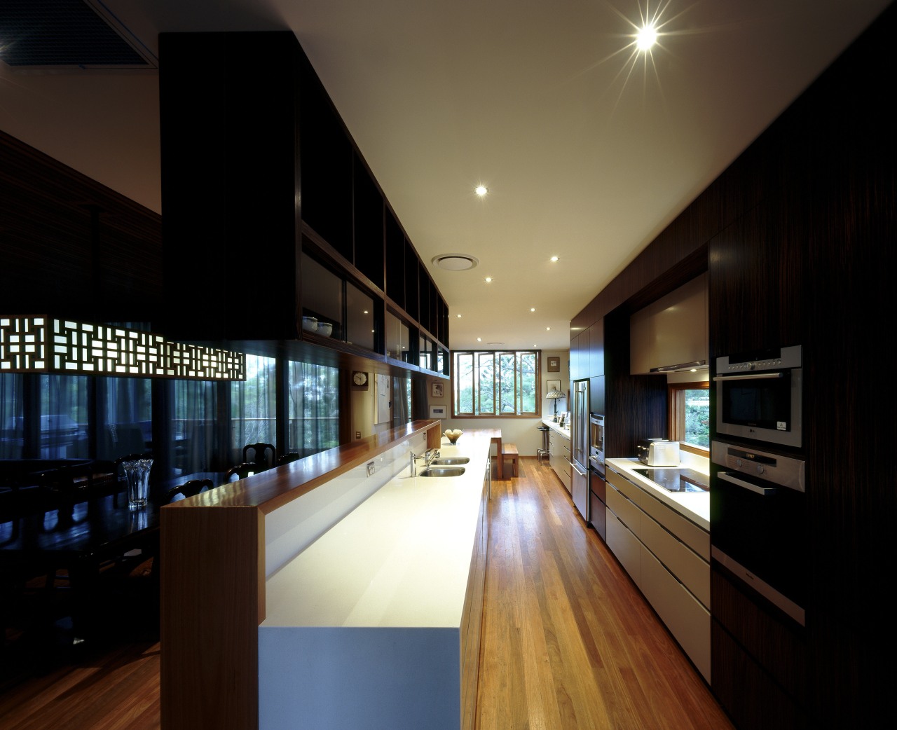 View of kitchen with wooden flooring, dark toned apartment, architecture, ceiling, daylighting, house, interior design, lighting, real estate, black, brown