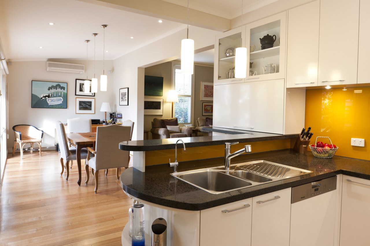 View of contemporary kitchen with white cabinetry, dark countertop, cuisine classique, interior design, kitchen, real estate, room, white, orange