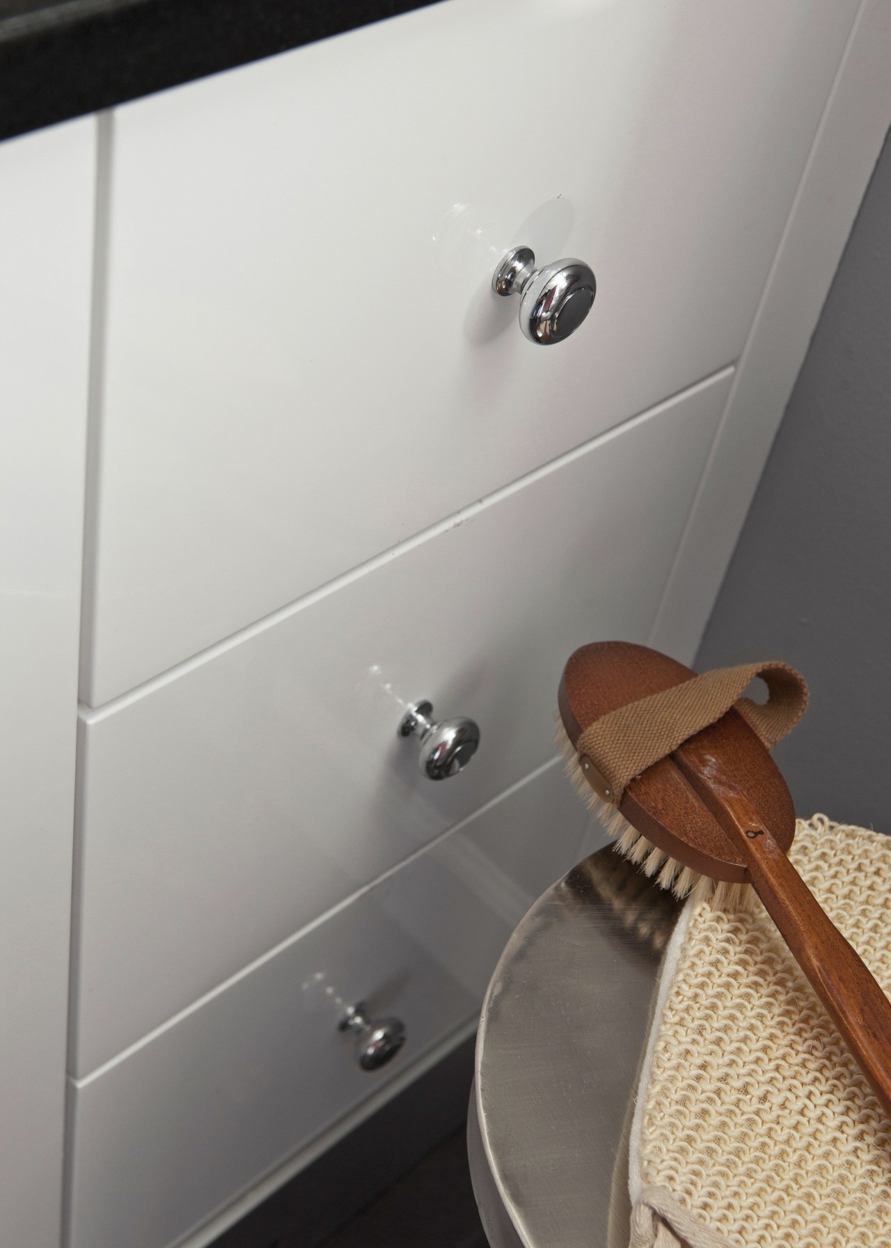 View of drawers and body scrubbing brush. bathroom, floor, plumbing fixture, product design, room, sink, tap, toilet seat, gray