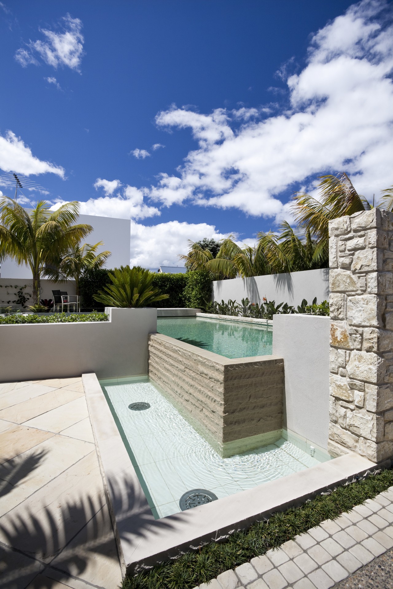 View of pool area of contemporary home. architecture, backyard, estate, home, house, outdoor furniture, outdoor structure, property, real estate, roof, sky, sunlounger, swimming pool, villa, white, blue