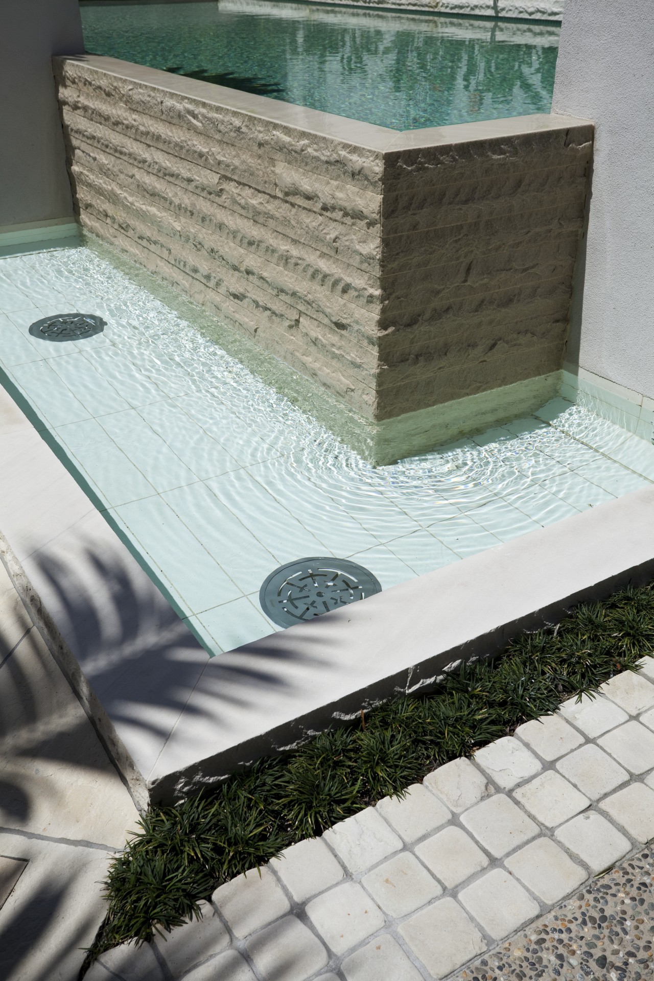View of pool area of contemporary home. floor, grass, table, gray