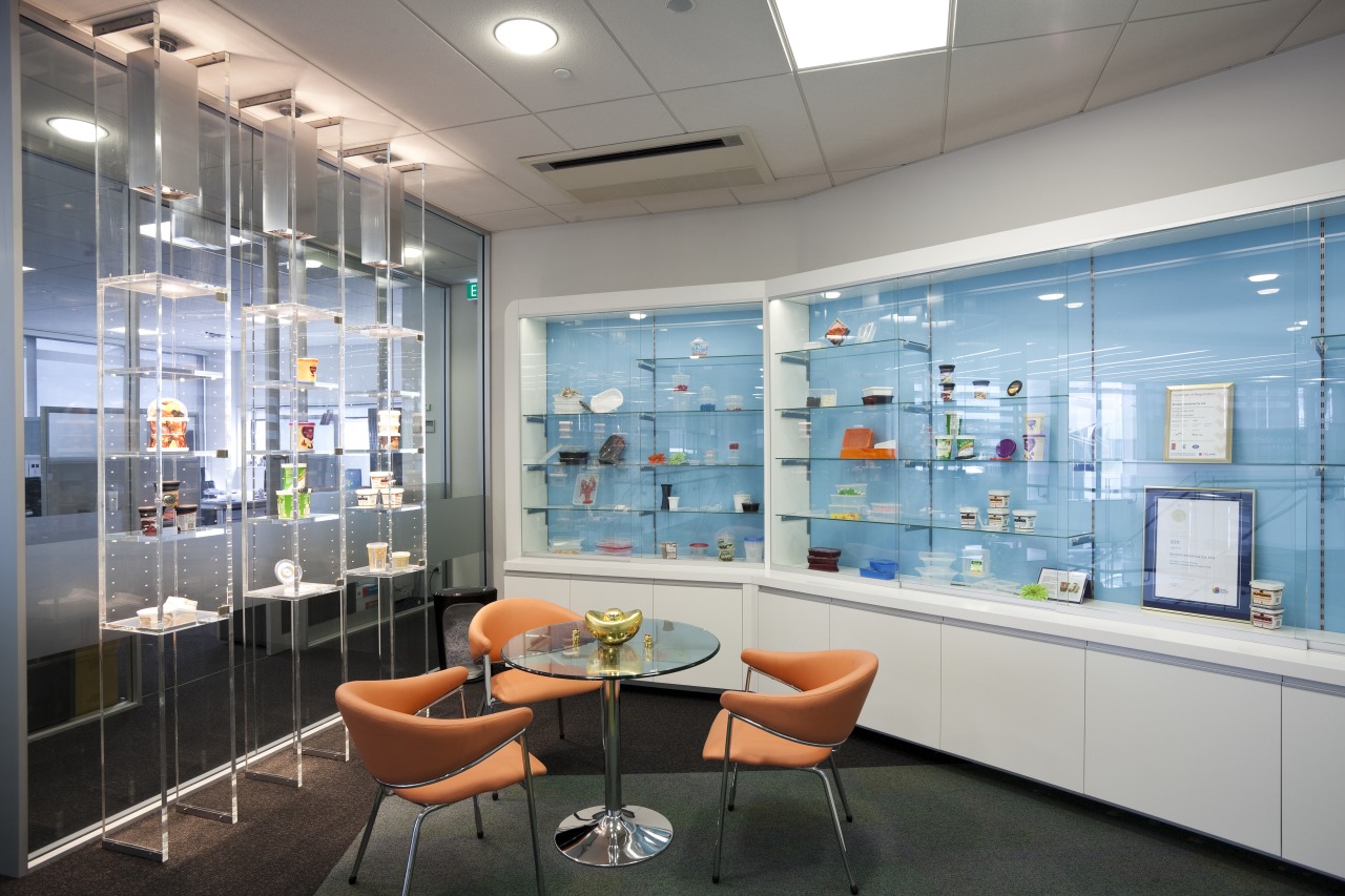 View of table and orange chairs. glass, interior design, office, gray