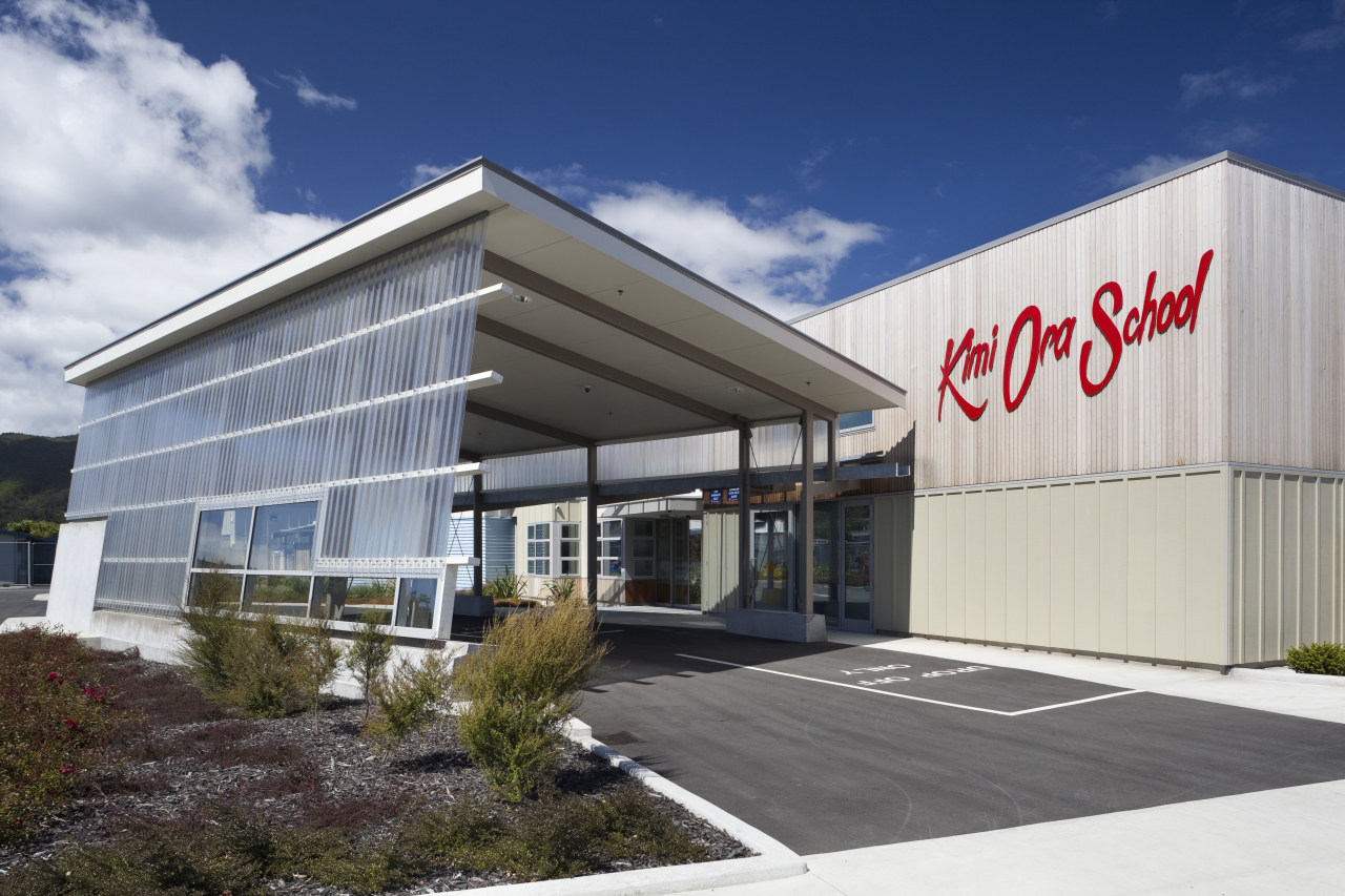 View of entrance to Kimi Ora school. building, commercial building, corporate headquarters, facade, property, real estate, gray