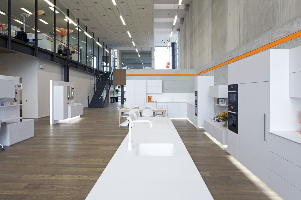 Showroom with white cabinetry and wooden flooring. daylighting, interior design, product design, gray, white