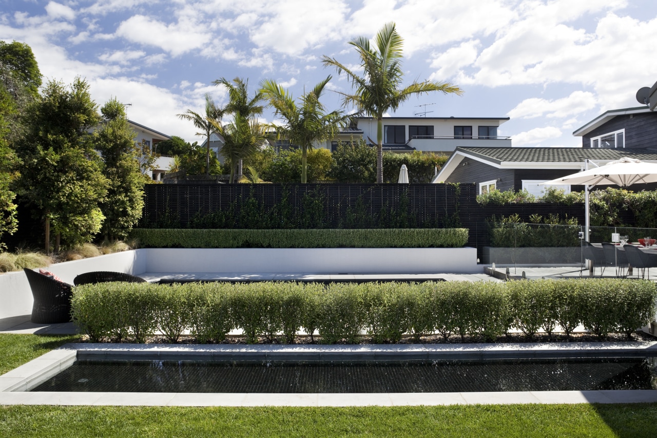 Here is a home designed by Belinda George architecture, backyard, estate, garden, grass, home, house, landscape, landscaping, lawn, luxury vehicle, plant, property, real estate, reflecting pool, residential area, swimming pool, villa, water, white