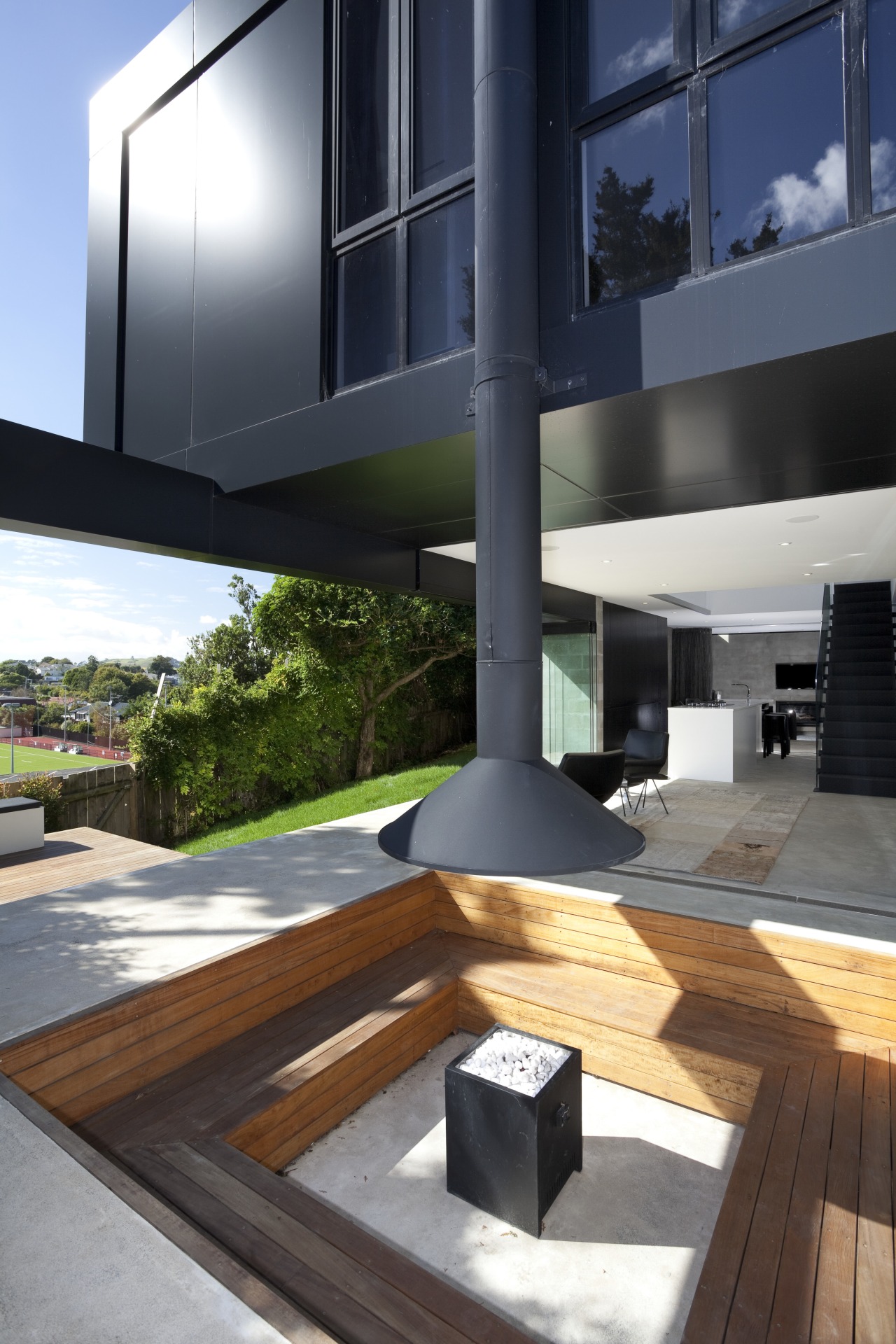 Fire pit seating area outside. Timber area, beneath architecture, condominium, daylighting, house, interior design, black