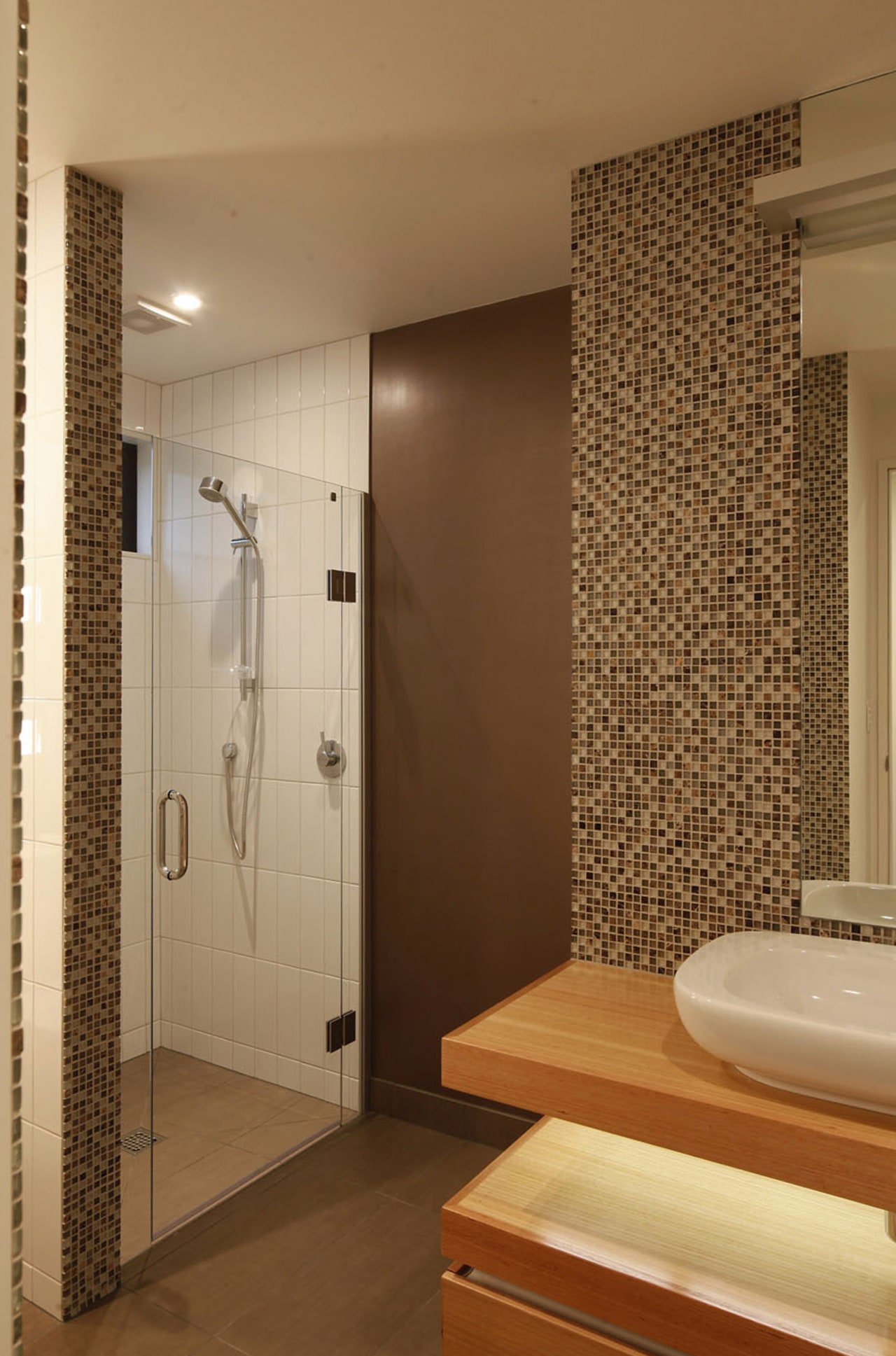 Bathroom with mosaic wall and glass shower enclosure. architecture, bathroom, floor, flooring, interior design, plumbing fixture, room, tile, wall, brown, orange