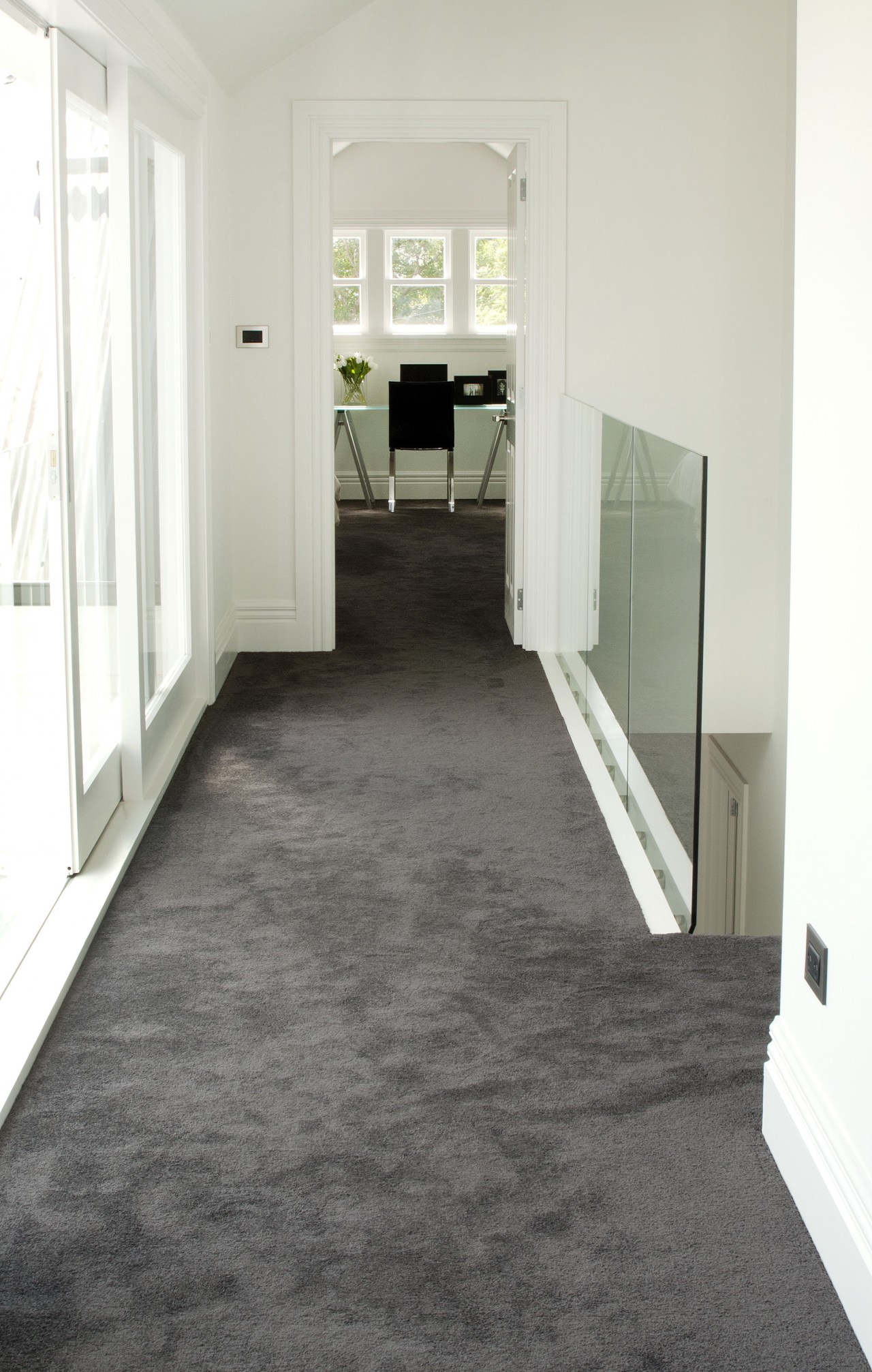 Hallway with grey carpet and white walls. floor, flooring, hardwood, home, house, laminate flooring, property, real estate, room, tile, wood, wood flooring, white, gray