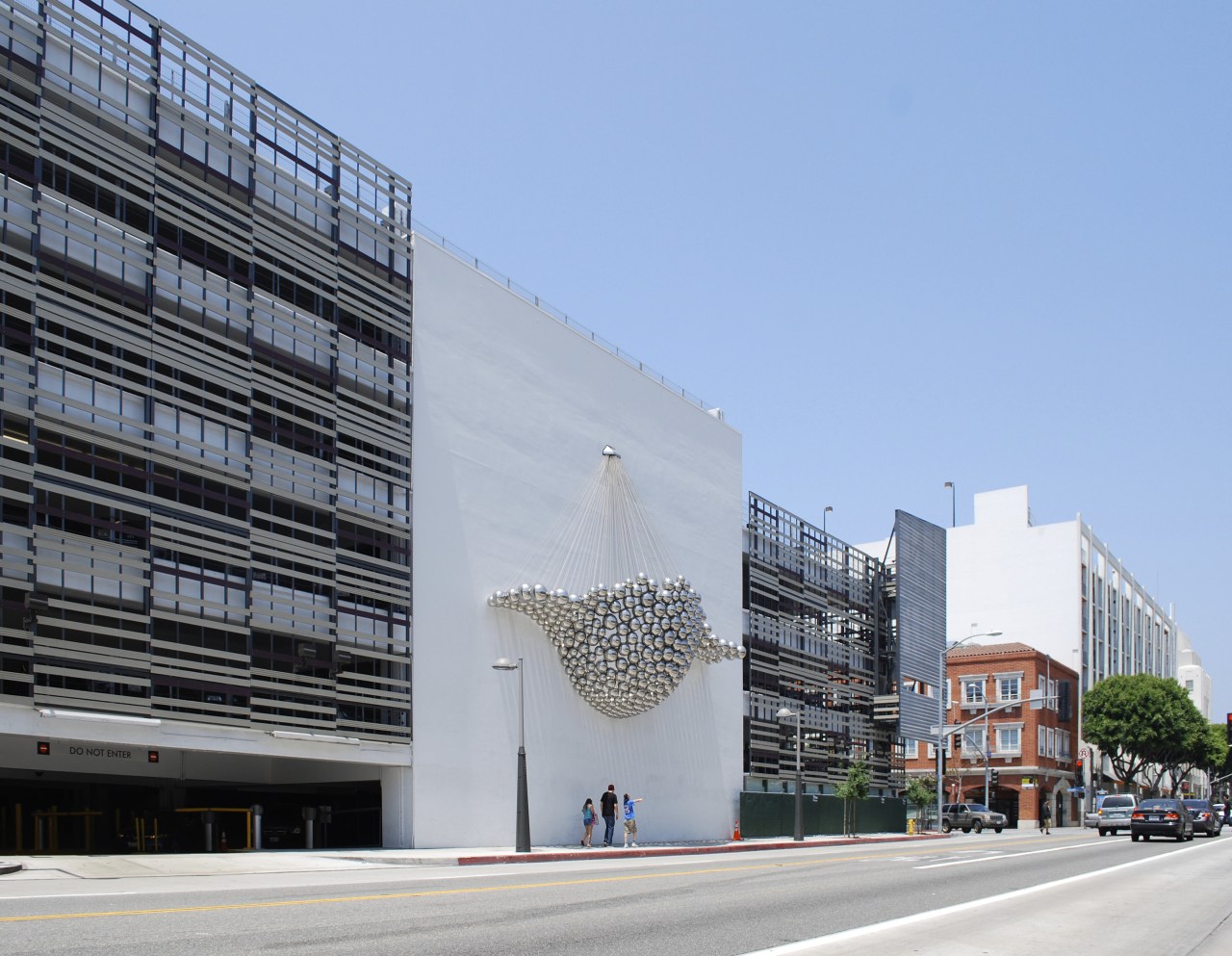 Parking garage with feature on wall. apartment, architecture, building, city, commercial building, condominium, corporate headquarters, daytime, facade, headquarters, metropolis, metropolitan area, mixed use, neighbourhood, residential area, sky, tower block, gray, teal