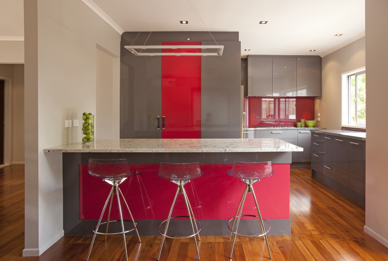 Streamlined grey kitchen with red accents. Peniinsula with cabinetry, countertop, floor, flooring, hardwood, interior design, kitchen, property, real estate, room, table, brown