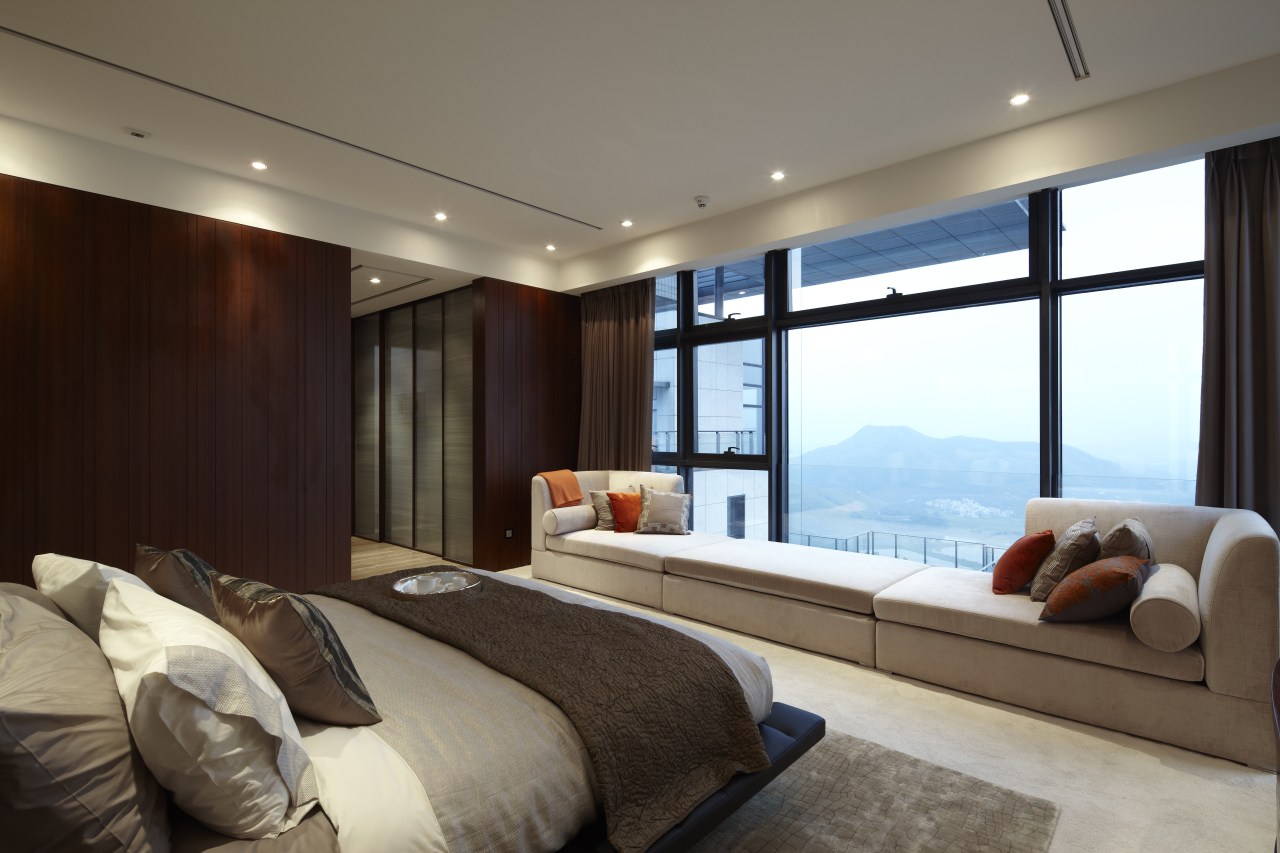 The master suite in this penthouse has a bedroom, ceiling, interior design, living room, property, real estate, room, suite, wall, window, gray