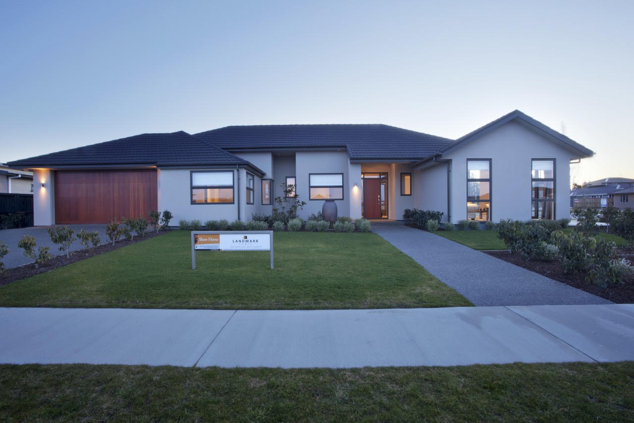 View of garage and house from street. cottage, elevation, estate, facade, home, house, landscape, property, real estate, residential area, roof, sky, teal