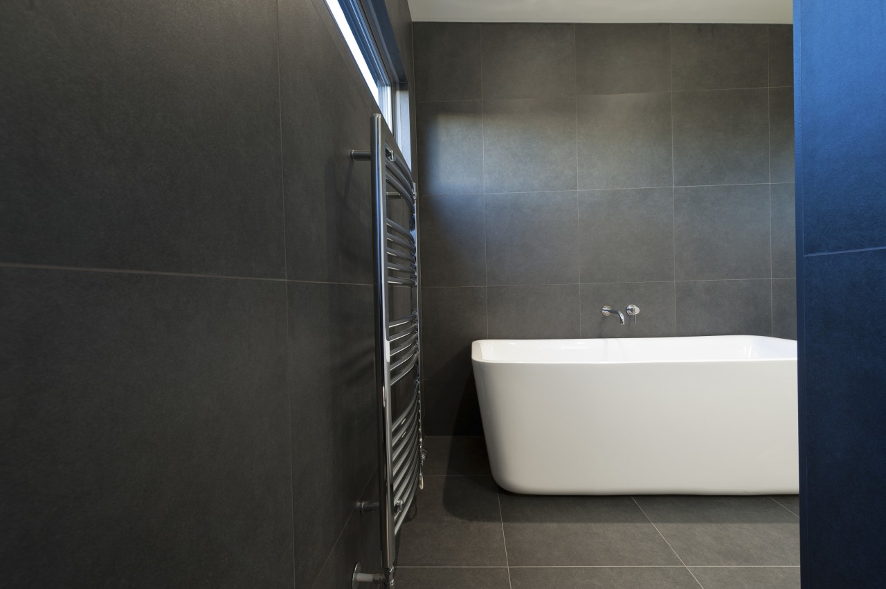 Bathroom remodel featuring gray basalt tiles, free-standing tub architecture, bathroom, floor, flooring, interior design, plumbing fixture, product design, property, room, tile, black, gray